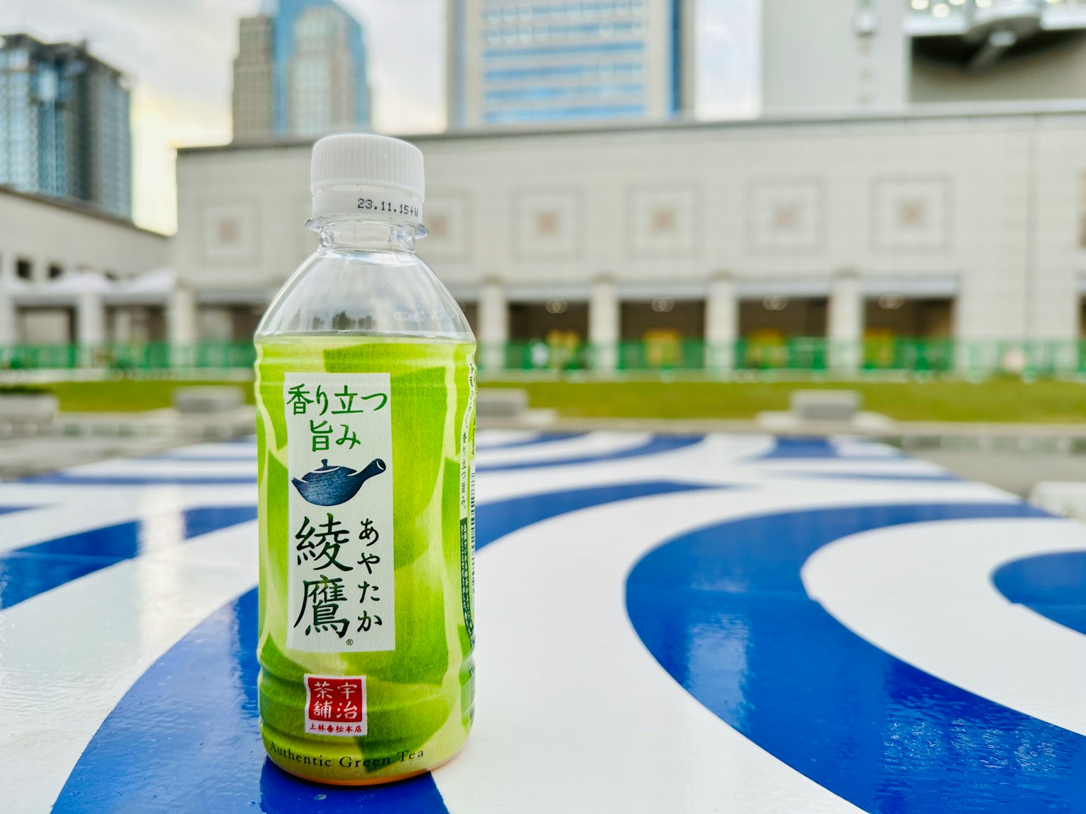 Chai trà xanh đặt trên bề mặt có họa tiết màu xanh lam
