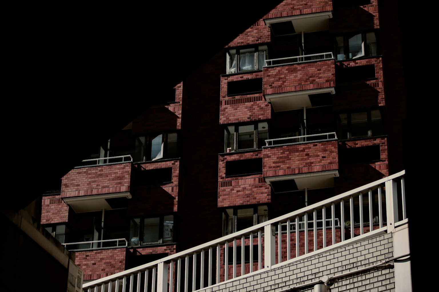 Eksterior gedung apartemen bata merah dengan balkon