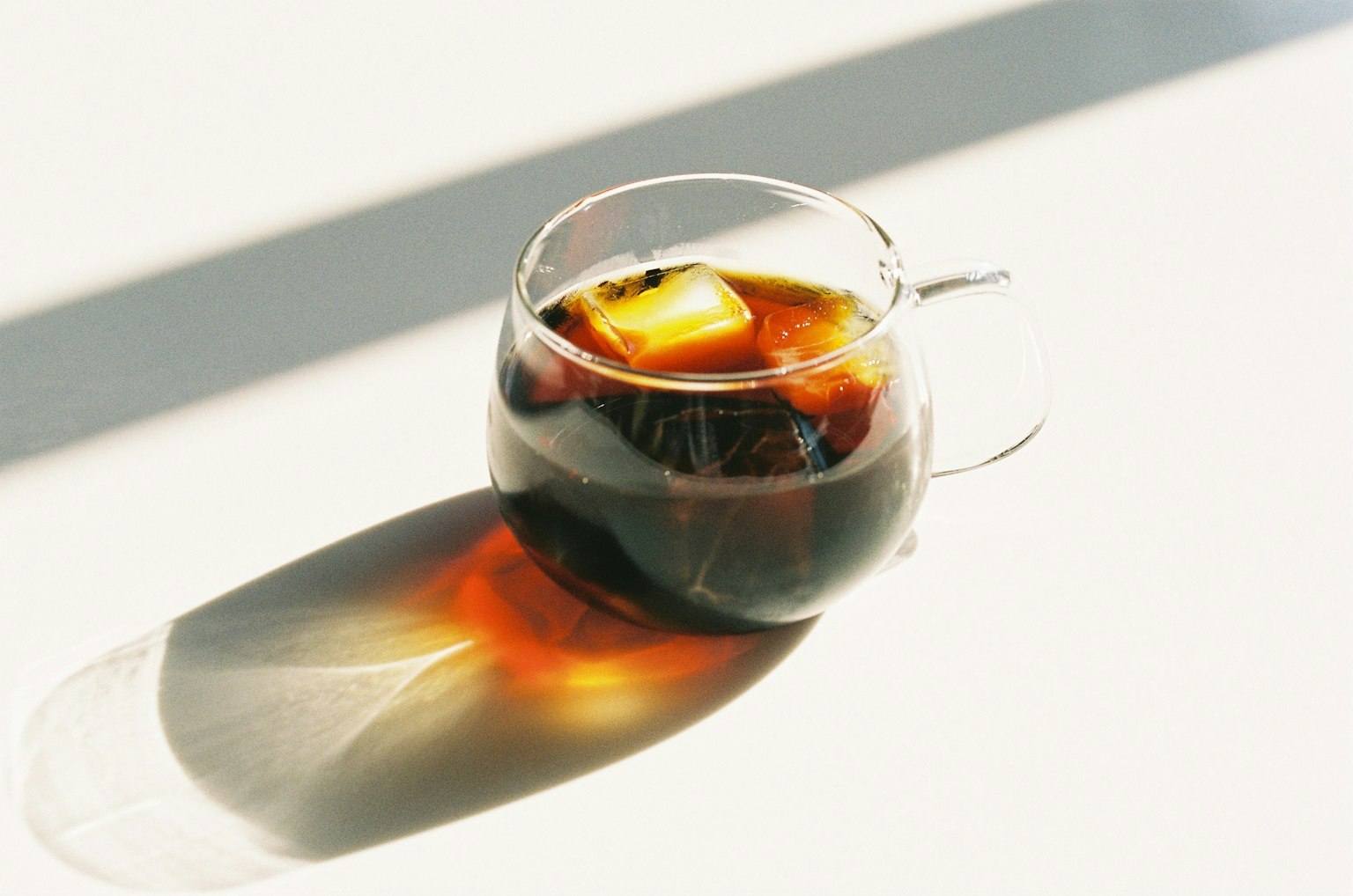 Tazza di vetro con caffè freddo e cubetti di ghiaccio