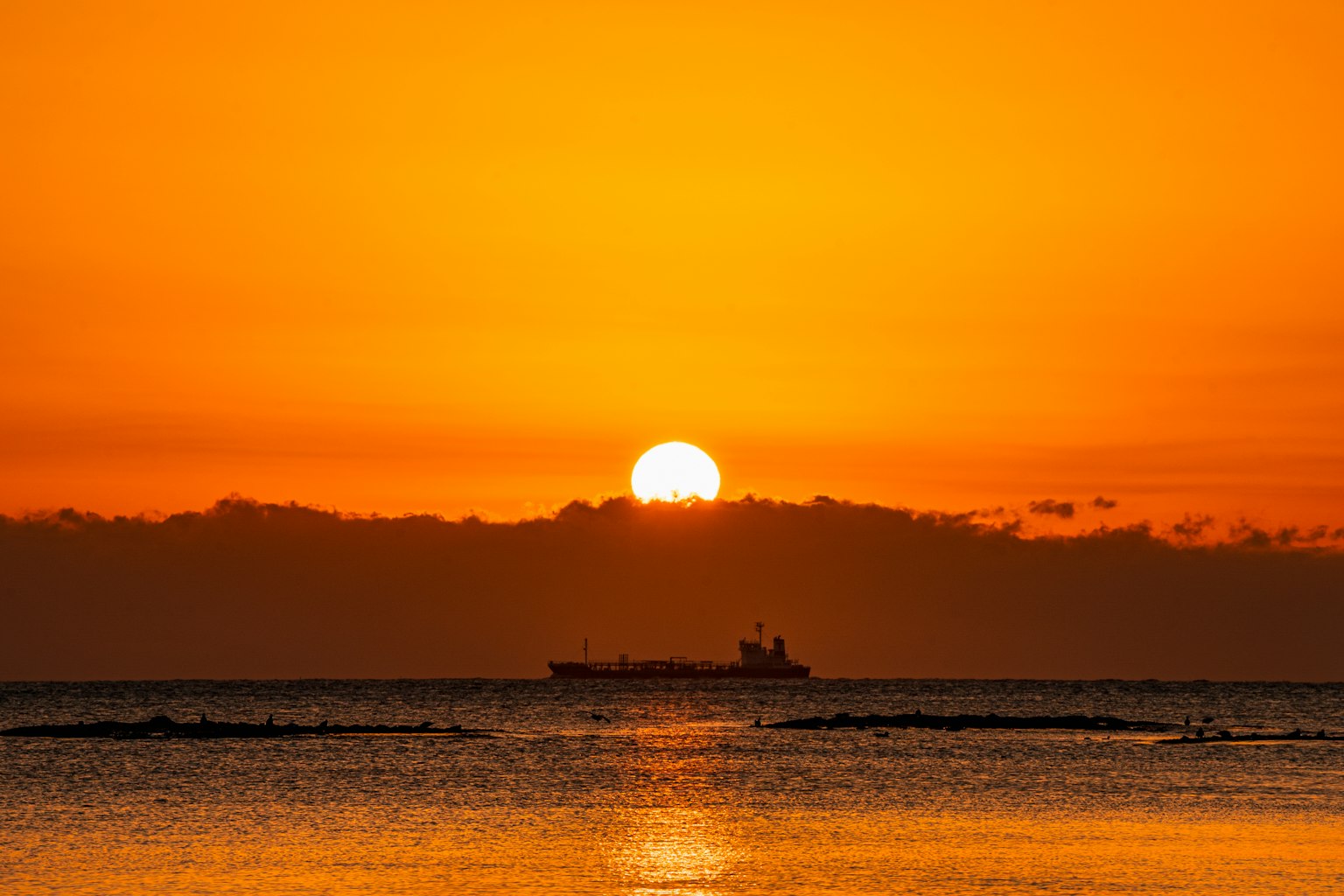 橙色天空下的海洋日落和轮廓分明的船