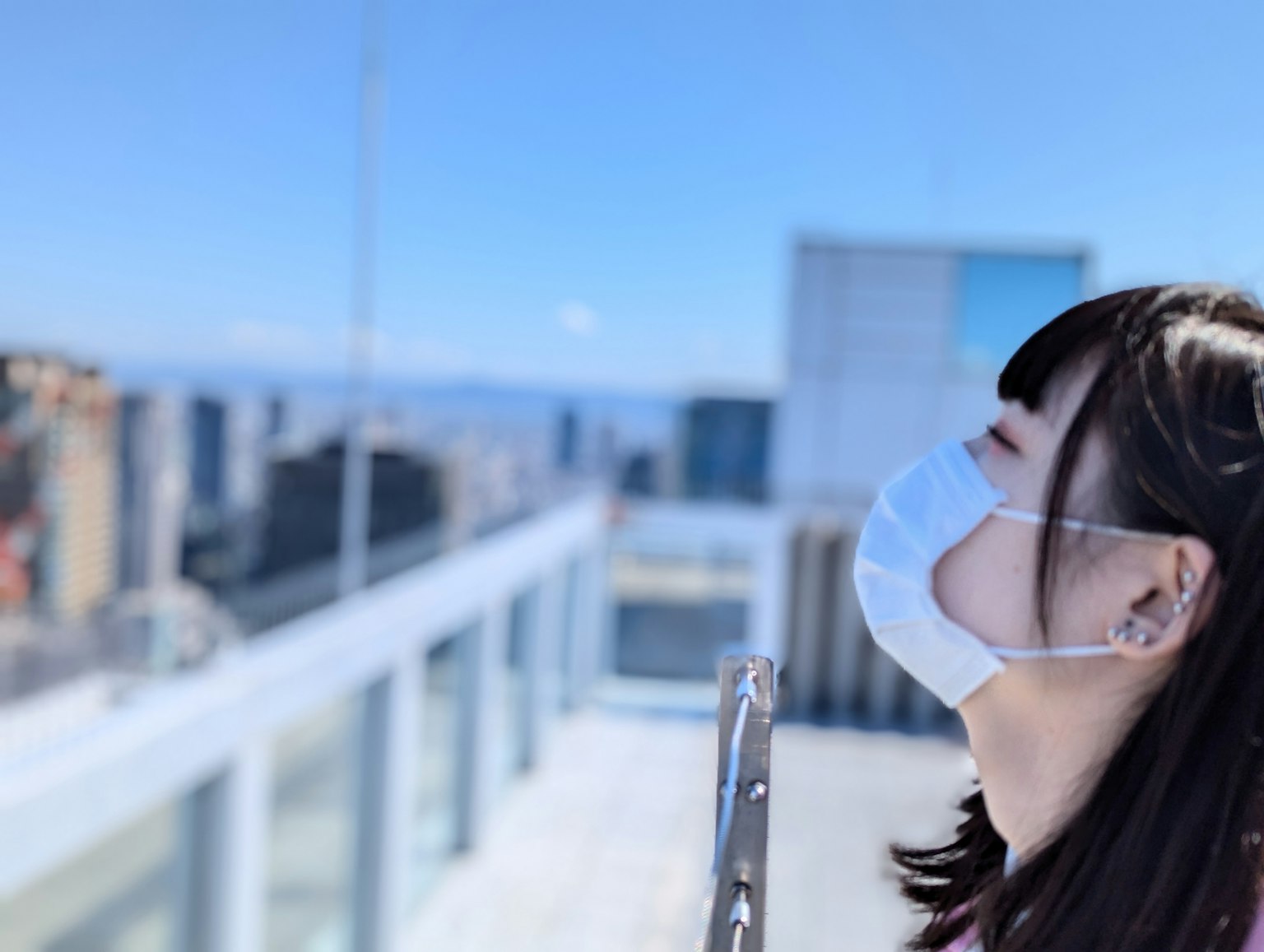 Una donna con una maschera che gode della brezza sotto un cielo blu