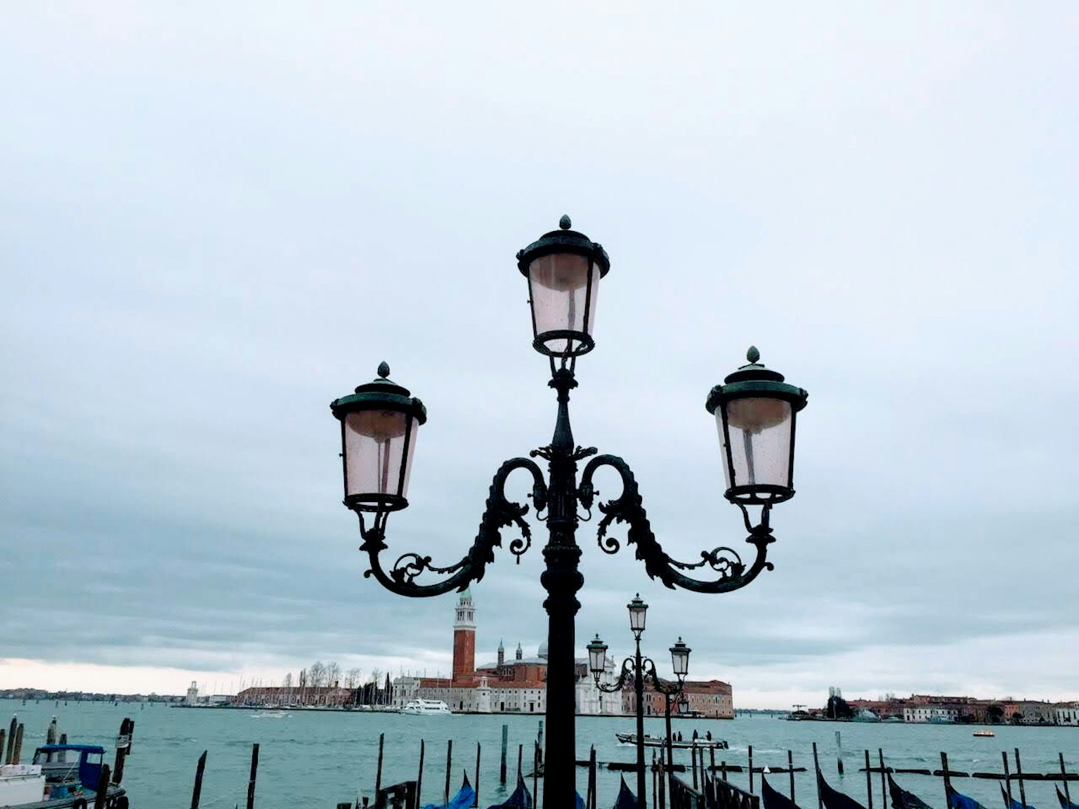 Lampione decorativo vicino all'acqua con vista su Venezia sullo sfondo