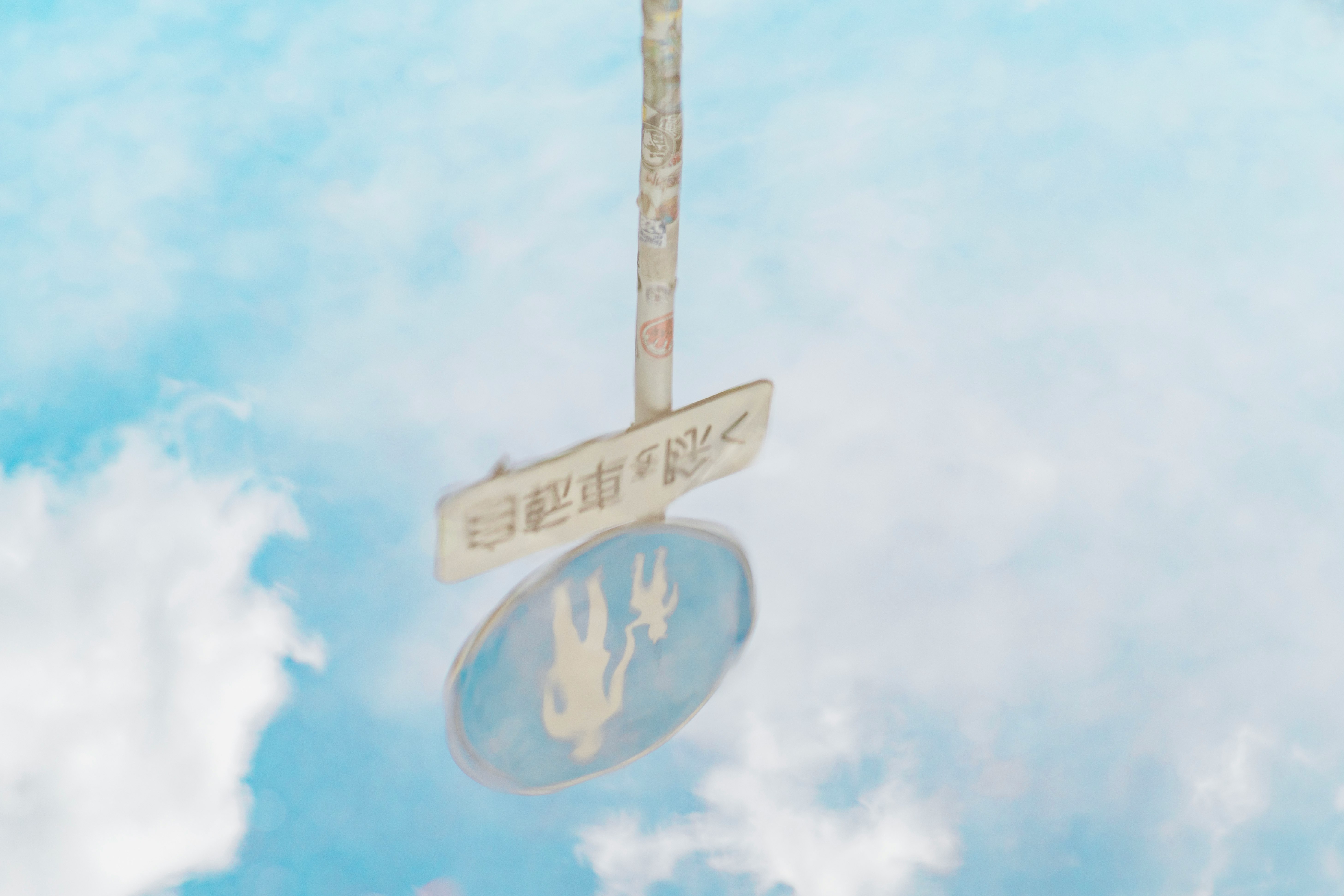 road sign and circular marker under a blue sky