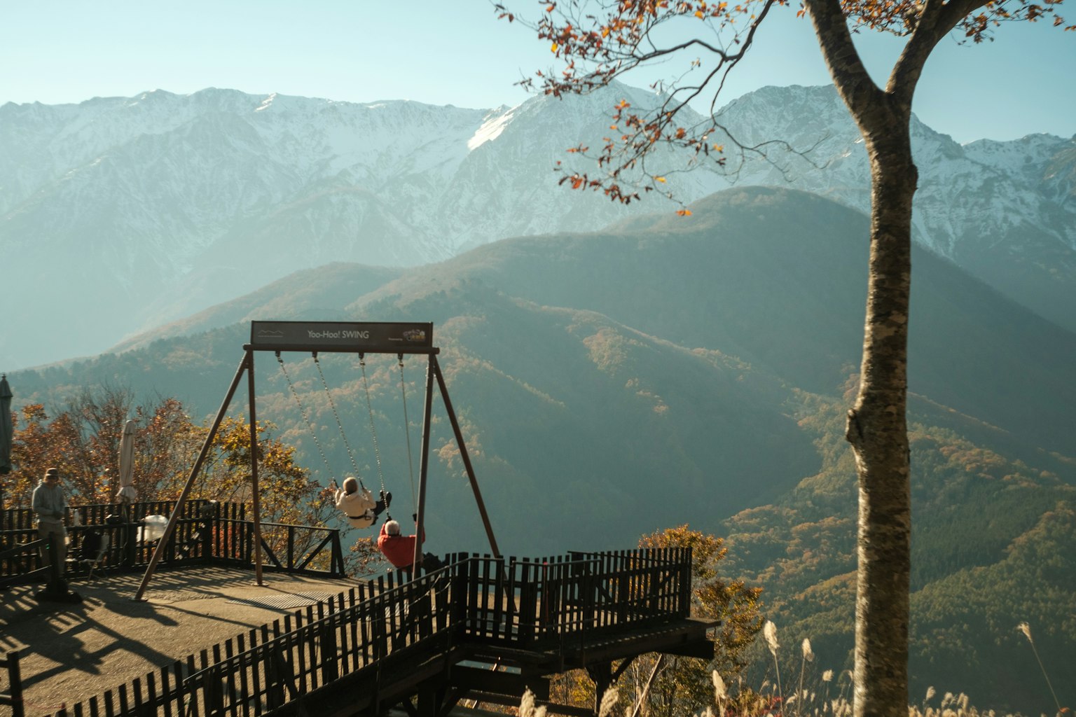 美しい山々を背景にした遊具のブランコがある展望台