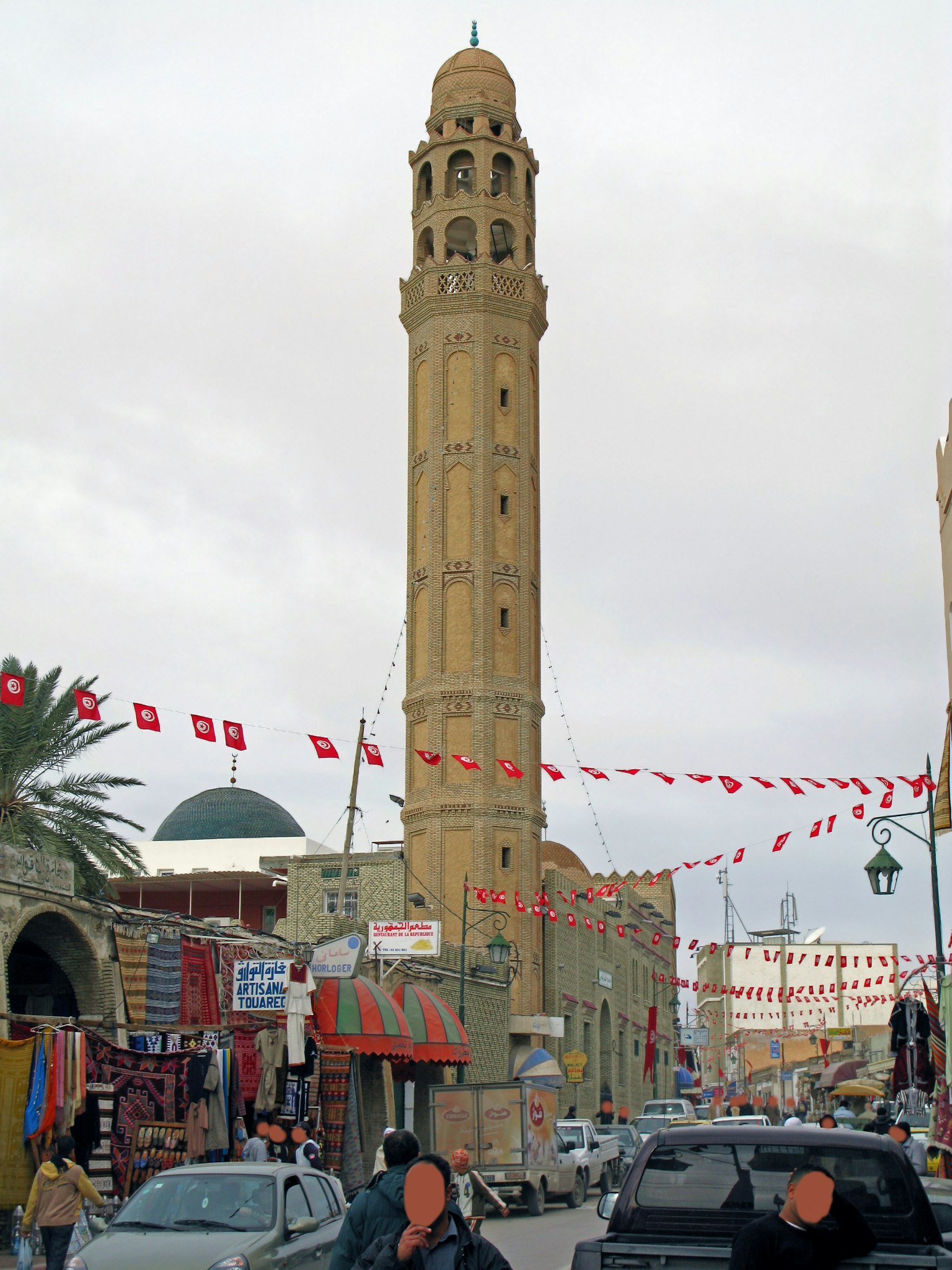 Menara tinggi dekat masjid dengan bendera berwarna-warni menghiasi jalan