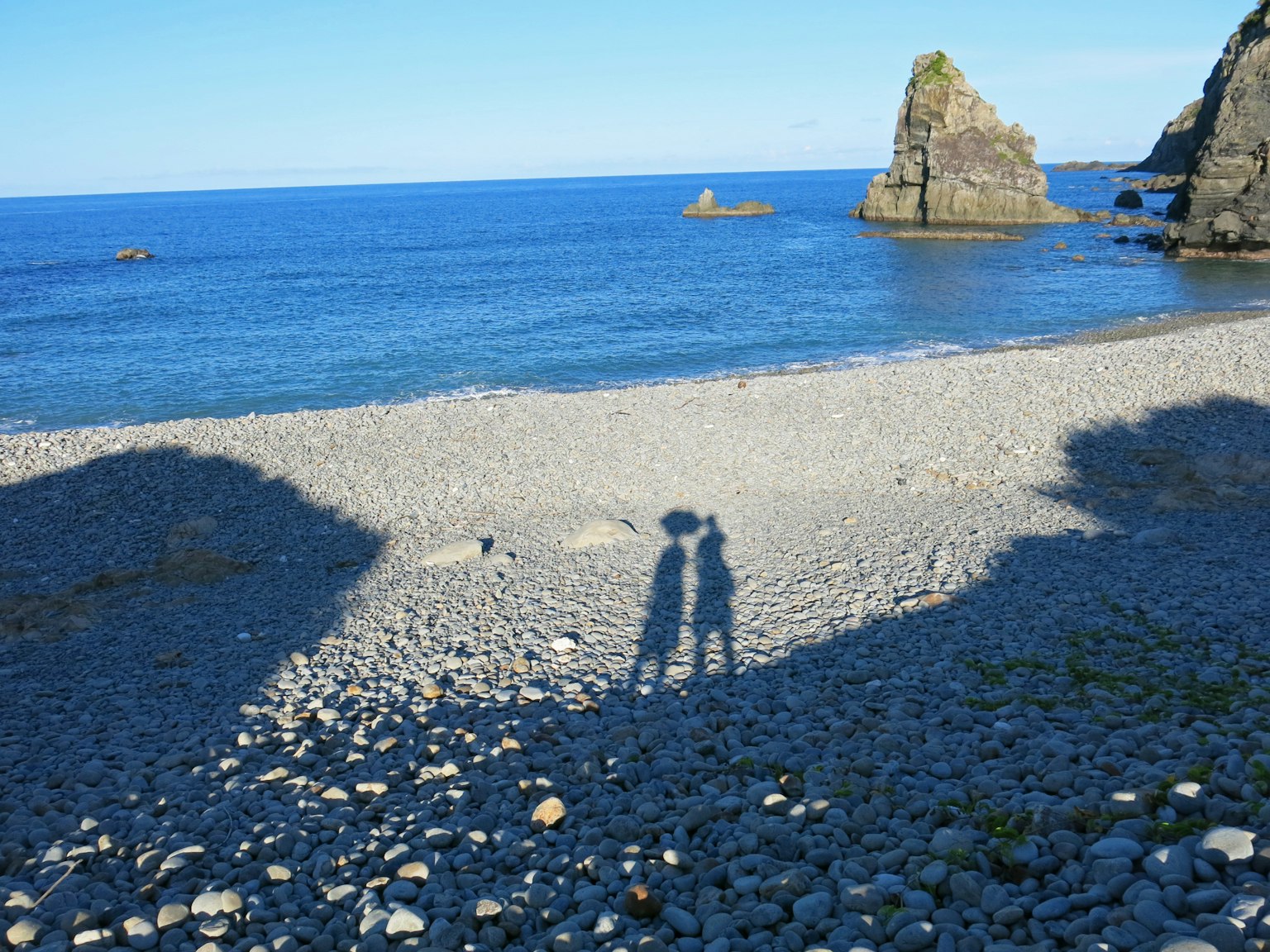 Silueta de una pareja contra un fondo de mar y rocas