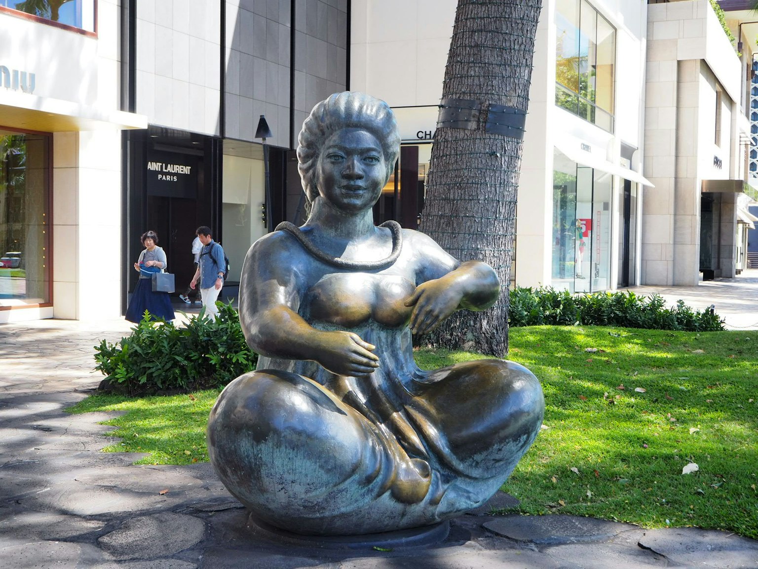 Scultura in bronzo di una donna seduta in un parco