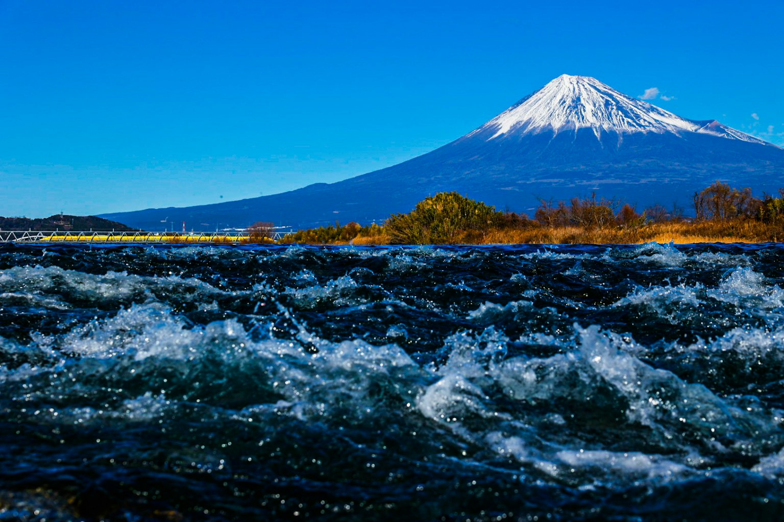 河水濺起，背景是藍天和富士山