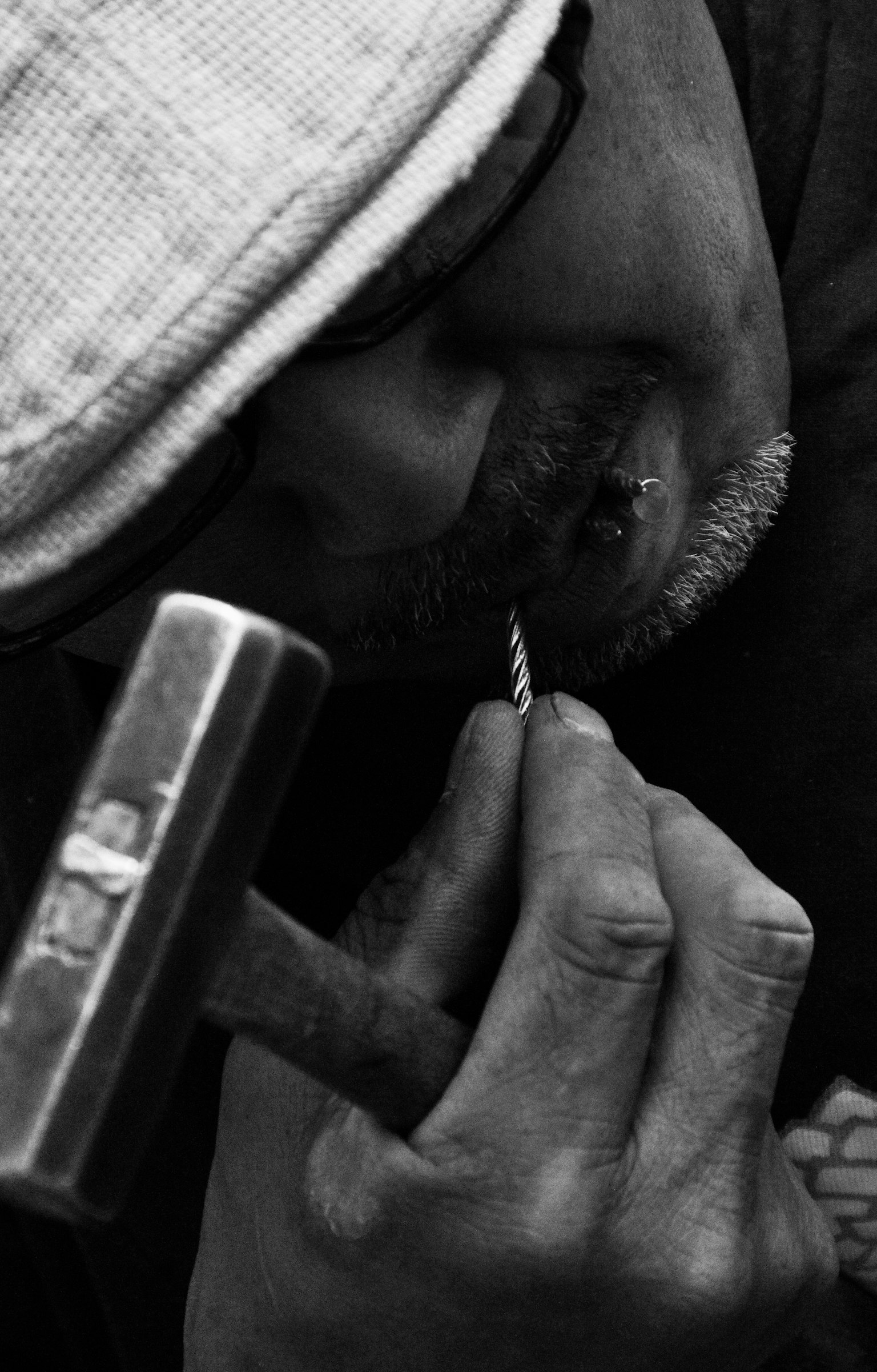 男性がハンマーを持ち、細かい作業をしているモノクロの画像