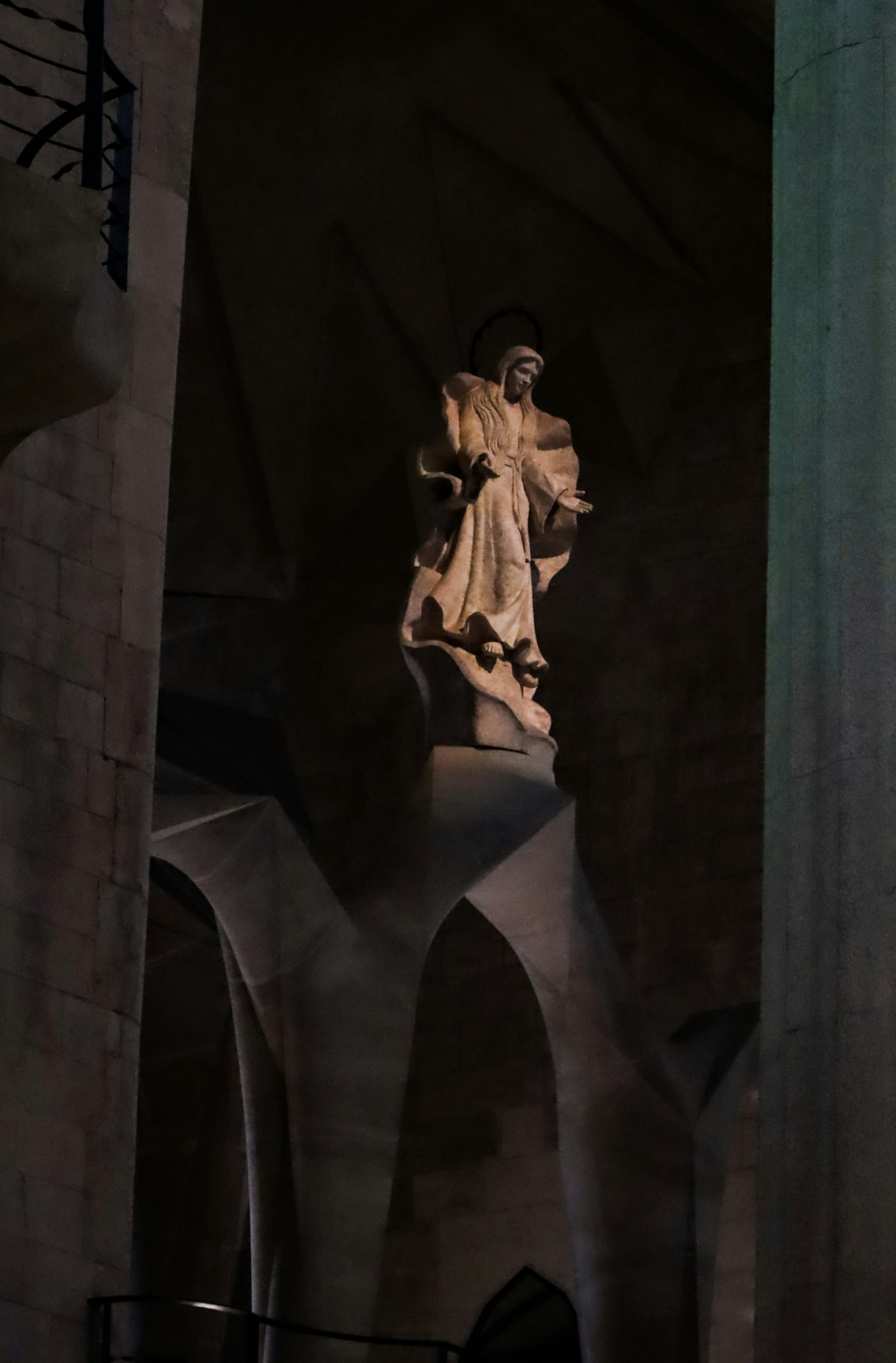Une statue se tenant à l'intérieur d'une église sombre