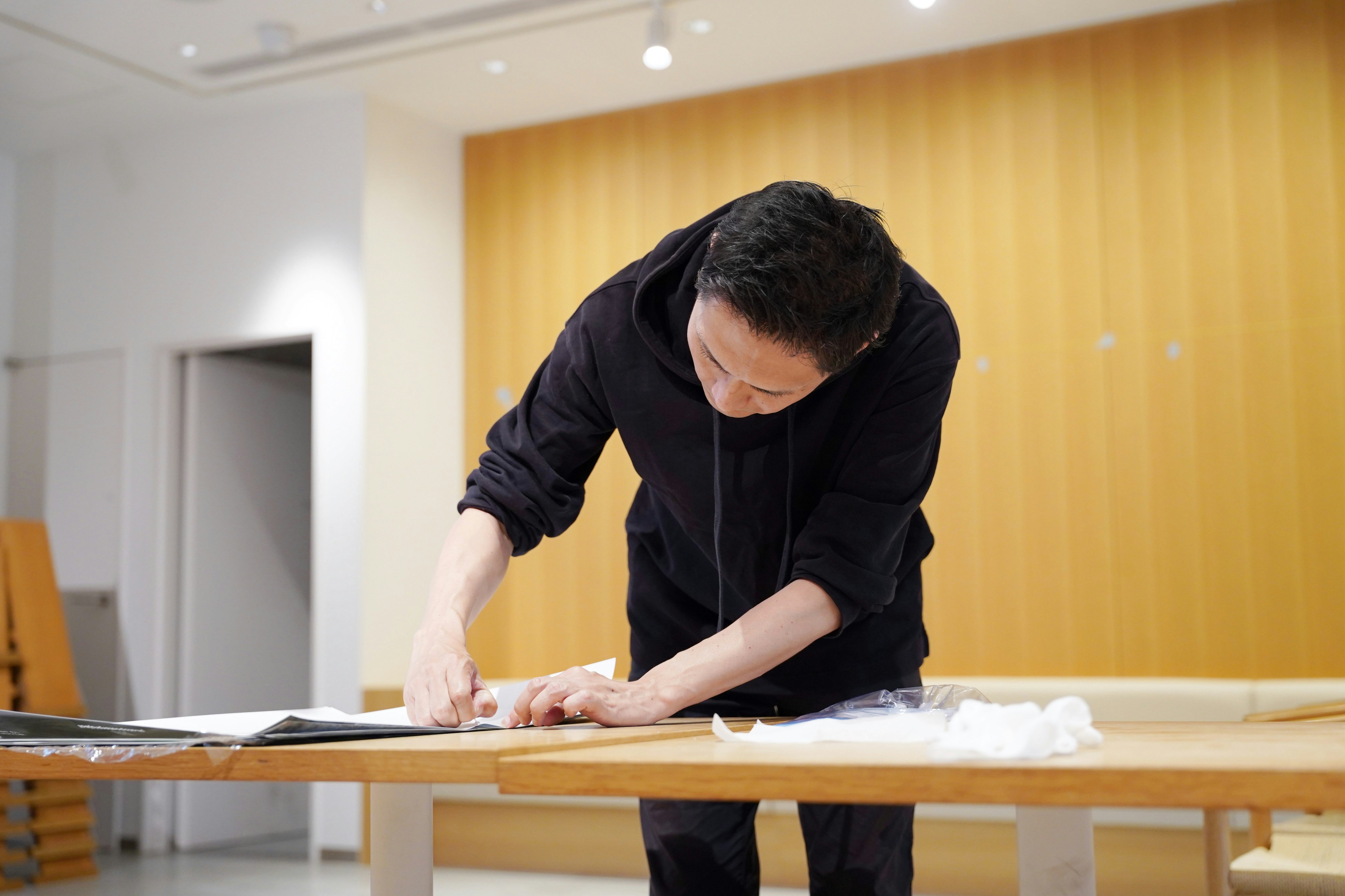設営中の作業者が机上で作業する室内風景