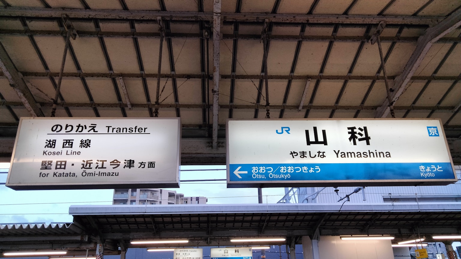 Tanda di Stasiun Yamashina menampilkan nama stasiun dan informasi transfer
