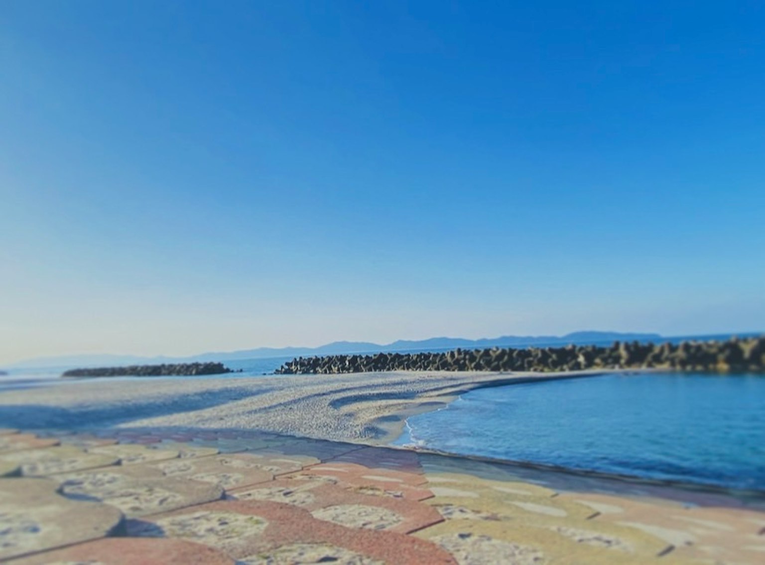 Pemandangan pantai dengan langit biru dan laut tenang