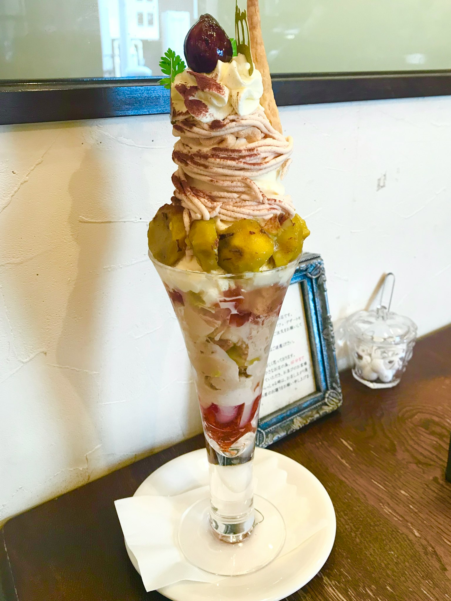 Delicious parfait in a tall glass layered with ice cream and fruits