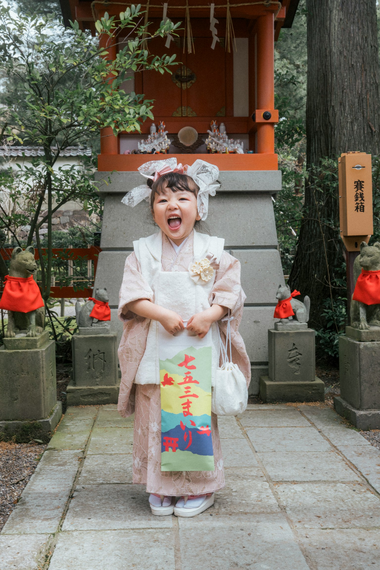 Una ragazza in kimono che sorride davanti a un santuario