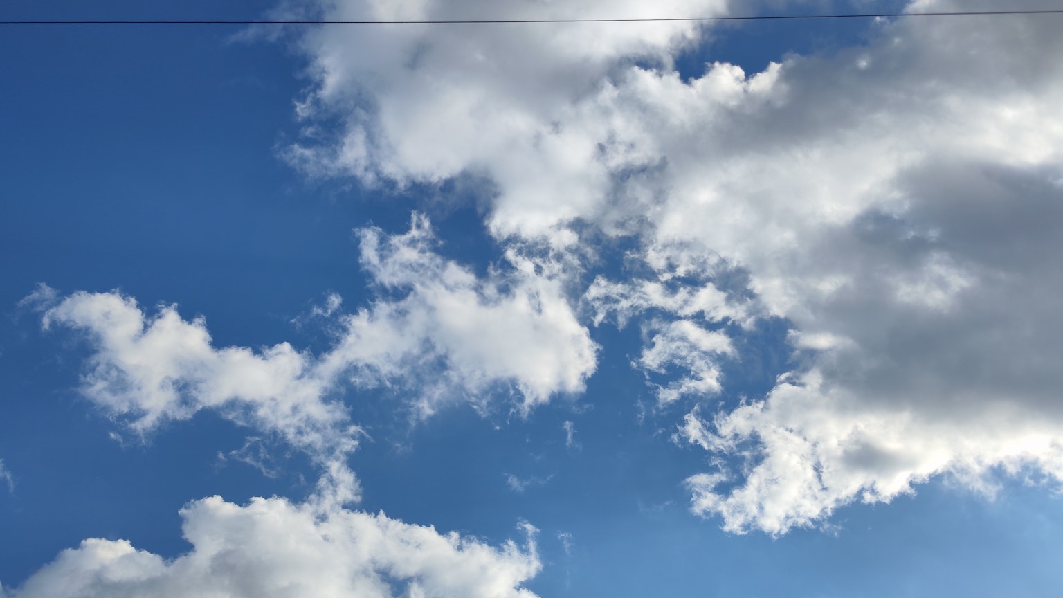 Landschaft mit weißen Wolken, die in einem blauen Himmel schweben