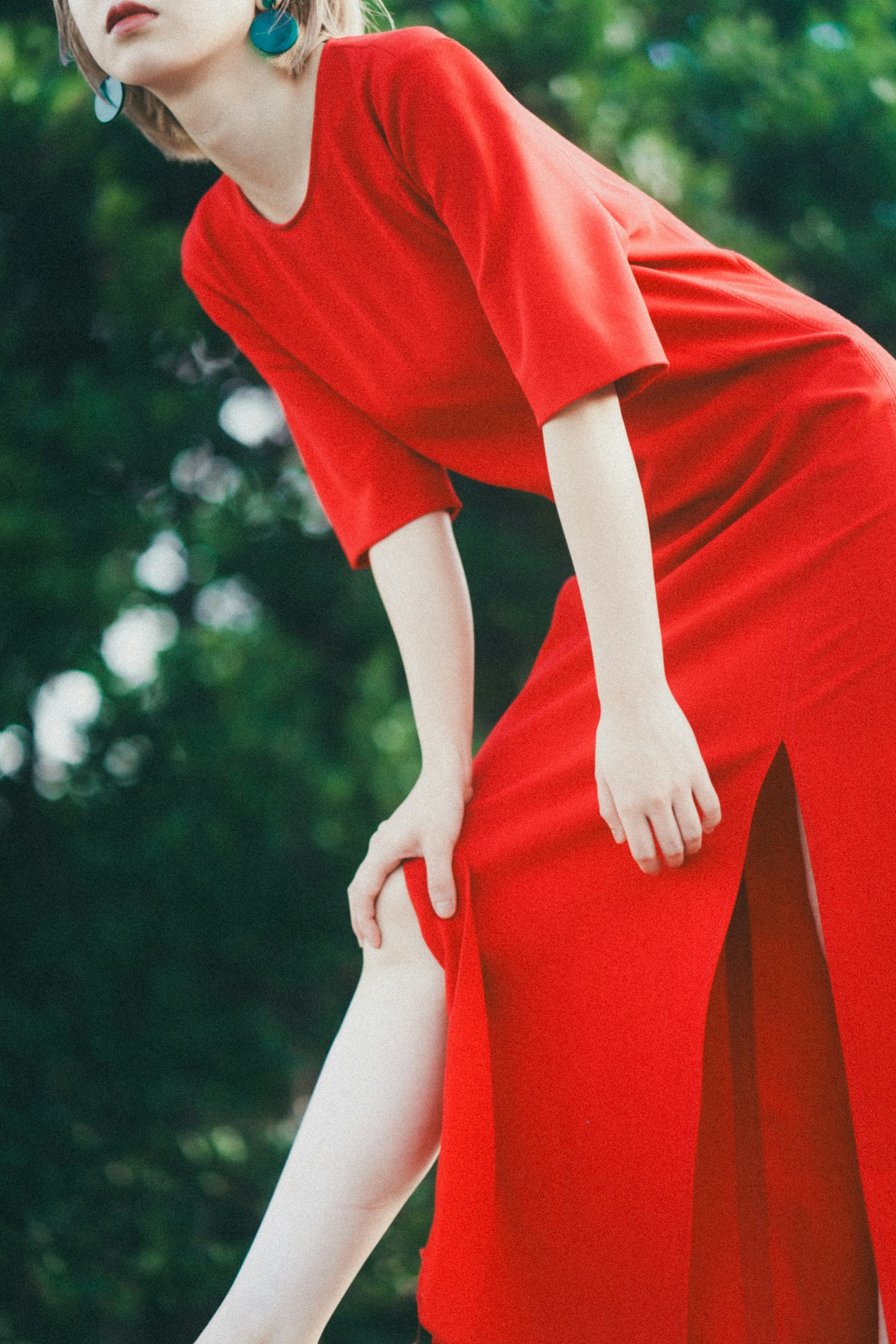 Modella che posa in un vivace vestito rosso con uno spacco alto