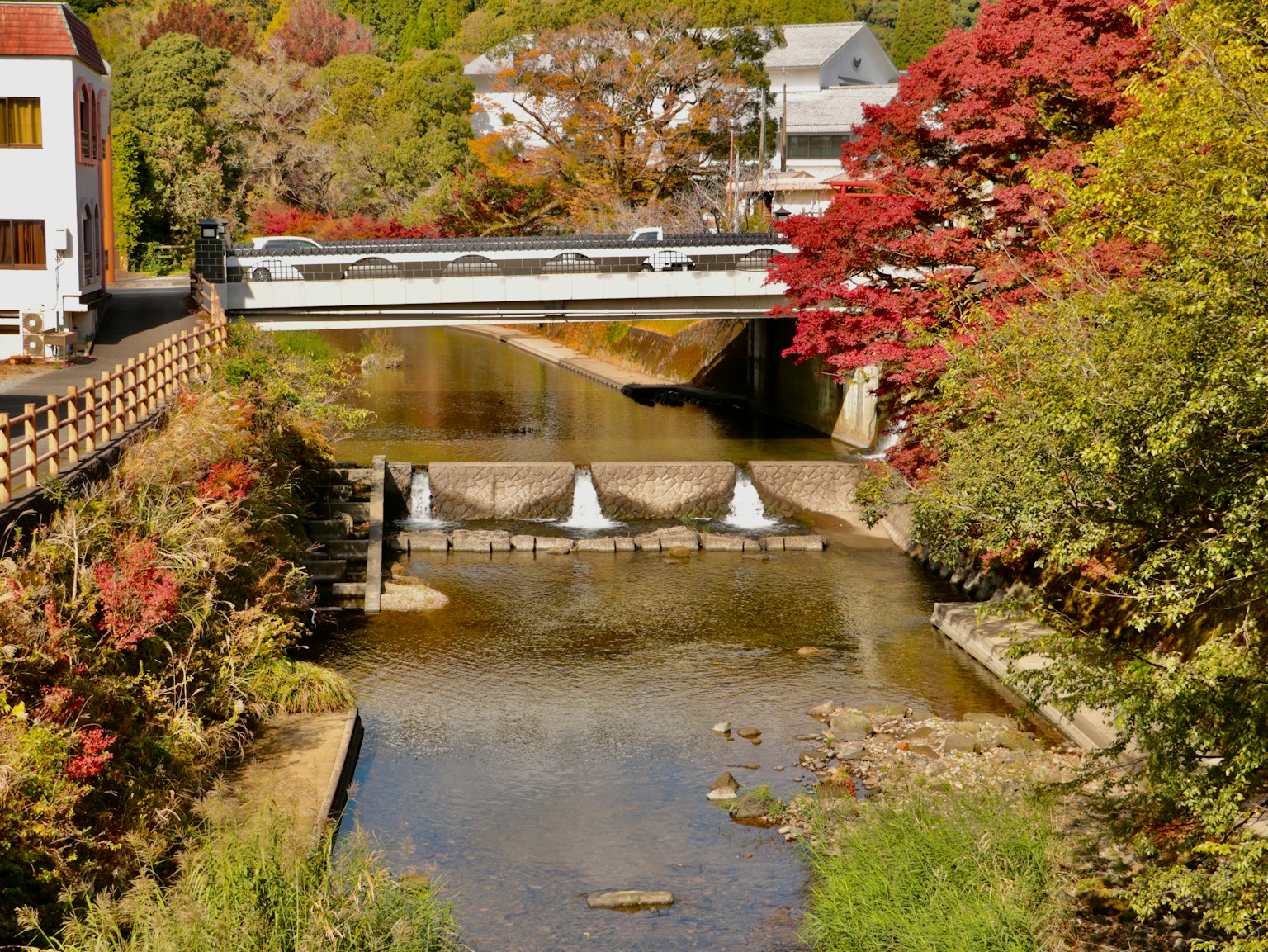 Ruisseau pittoresque avec un pont entouré de feuillage d'automne