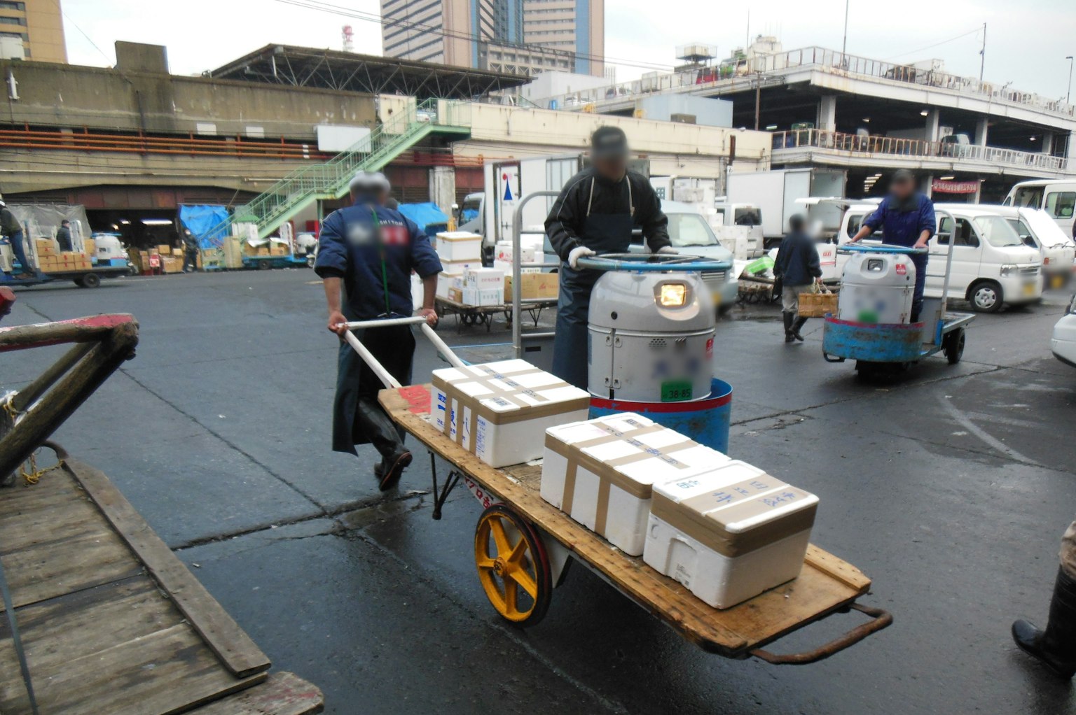 Workers transporting packages with a cart at a market