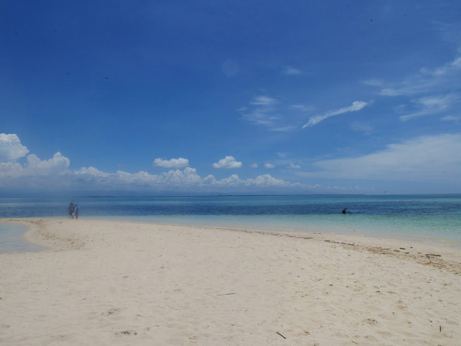 Vista panoramica di una spiaggia con cielo blu e sabbia bianca