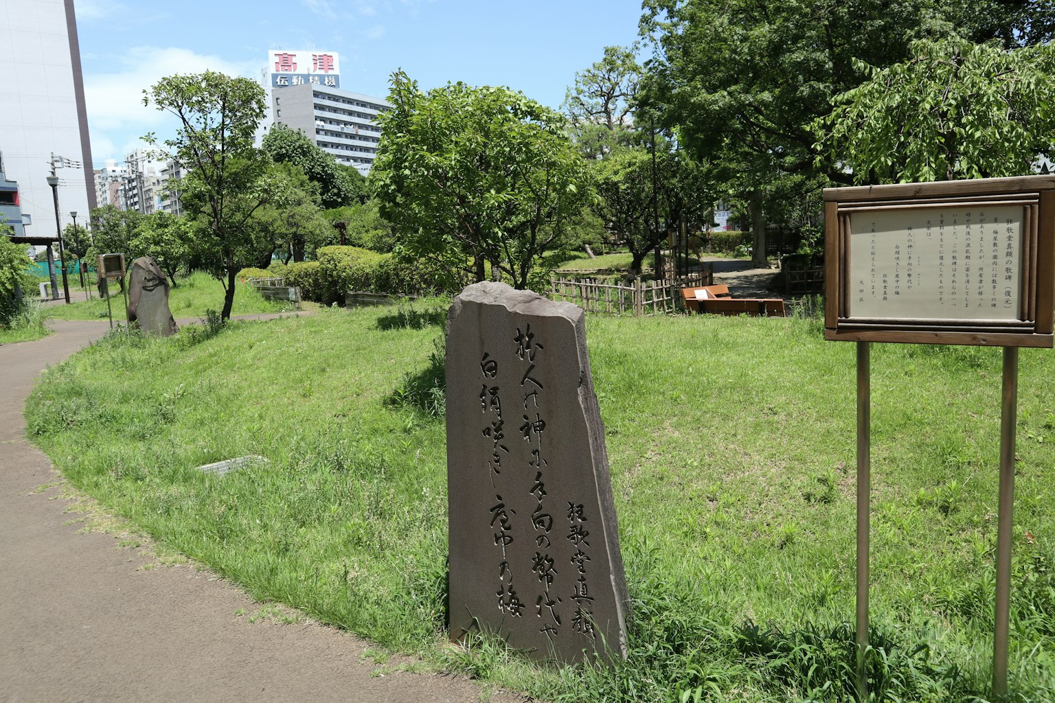 Paisaje con un monumento de piedra y un panel informativo en un parque