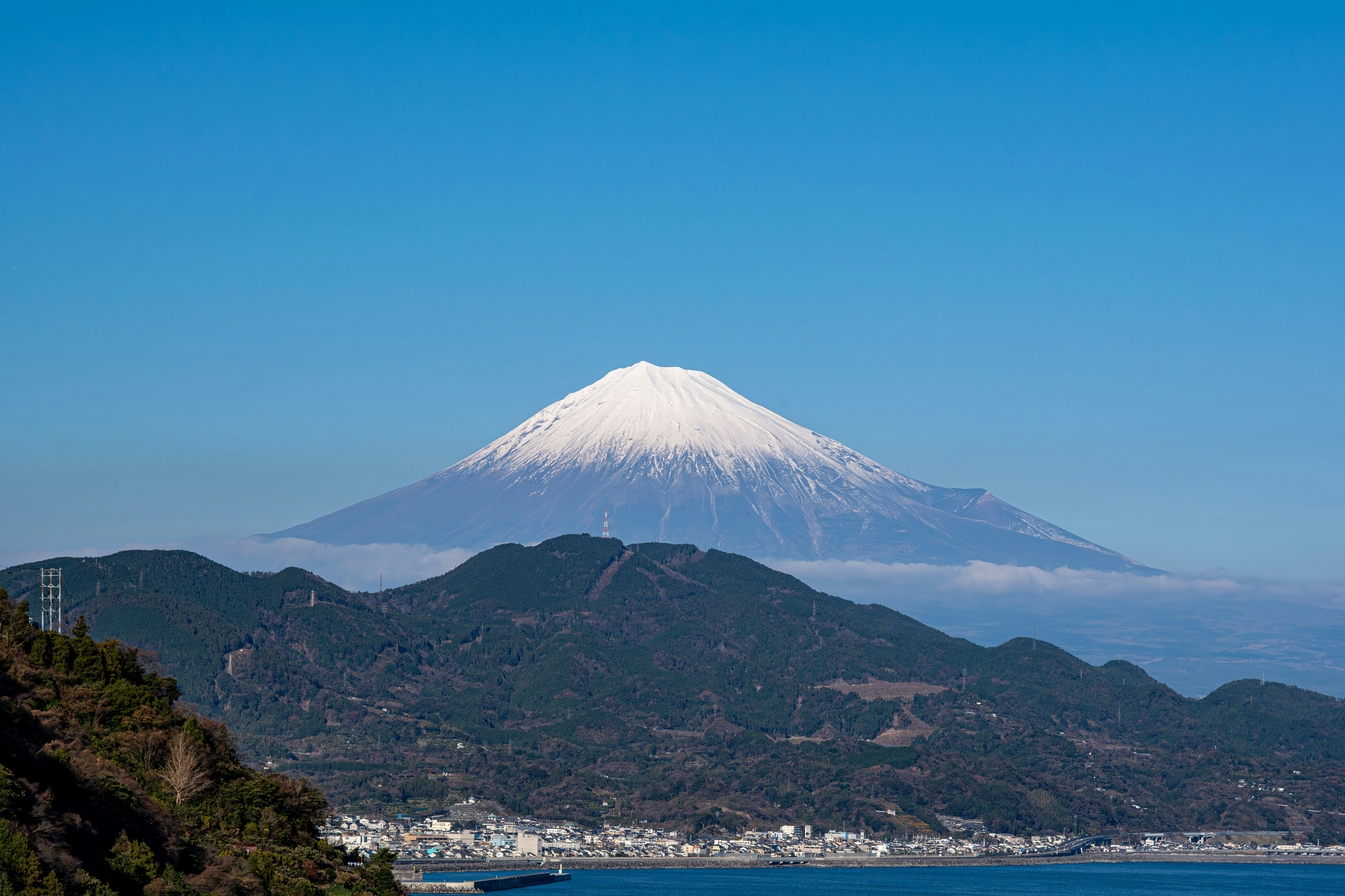 白雪覆盖的富士山与海边城镇景观
