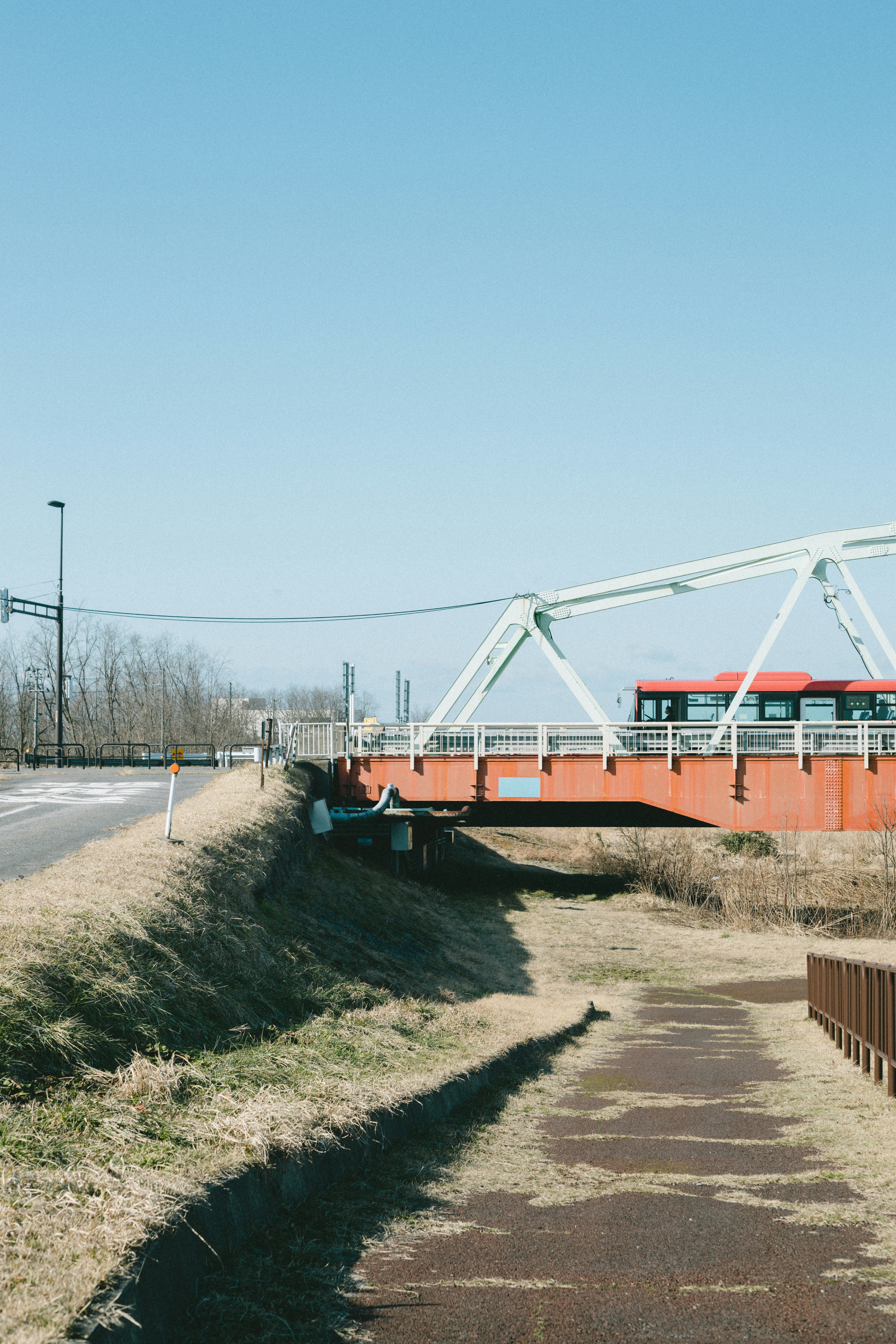 Red bridge under blue sky with surrounding landscape