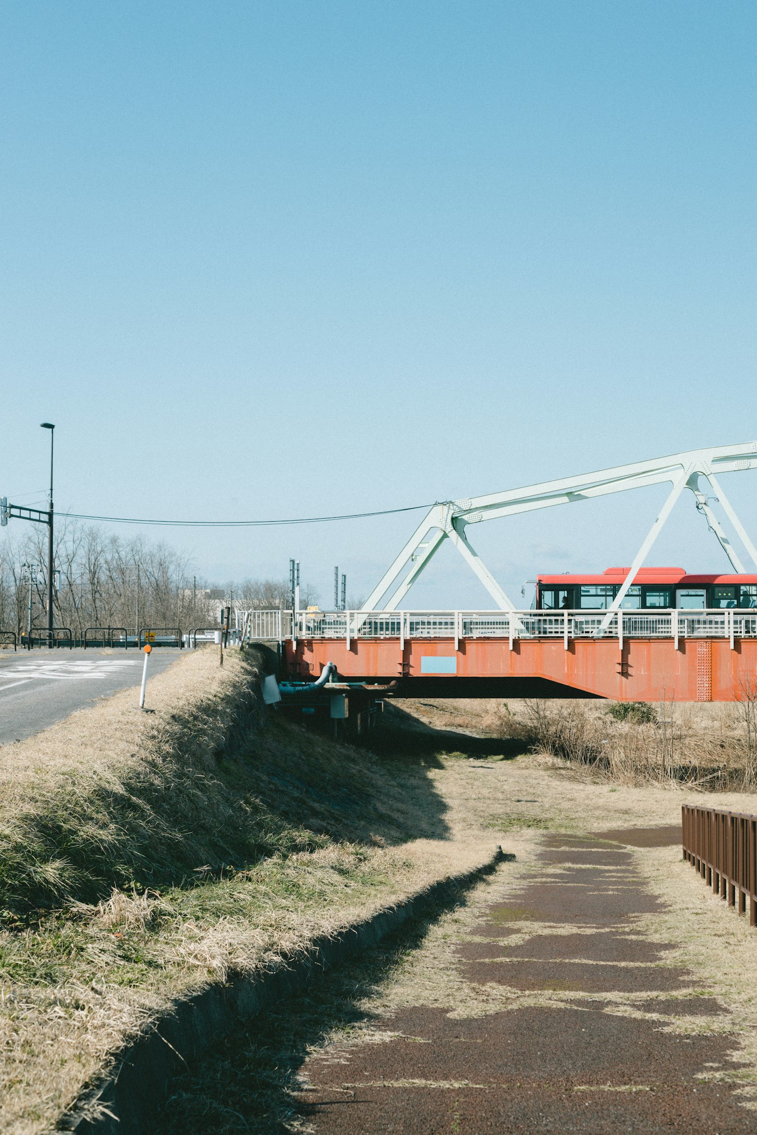 Ponte rosso sotto un cielo blu con paesaggio circostante