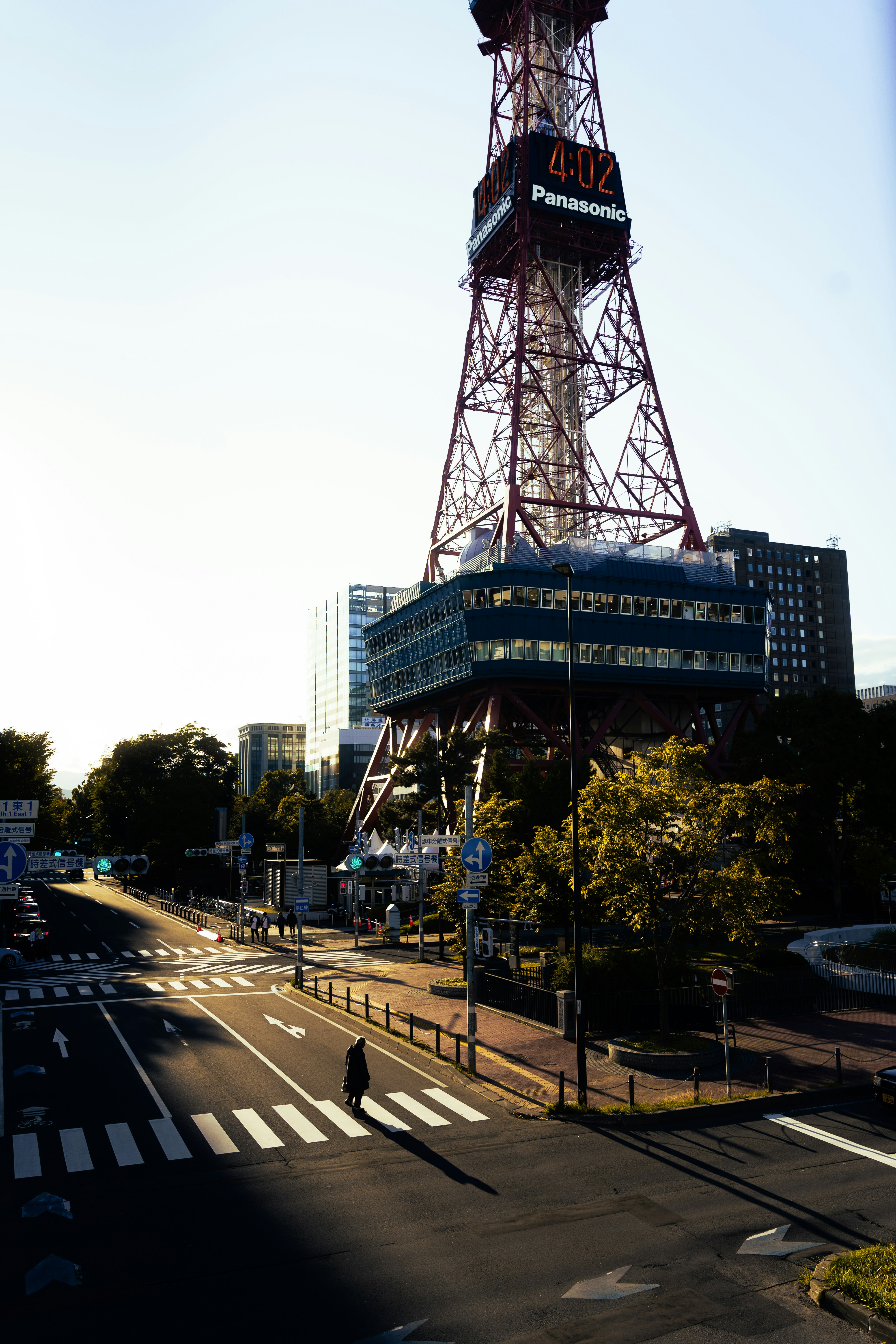 「4-02 Panasonic」の表示がある高い送信塔と都心の交差点の風景