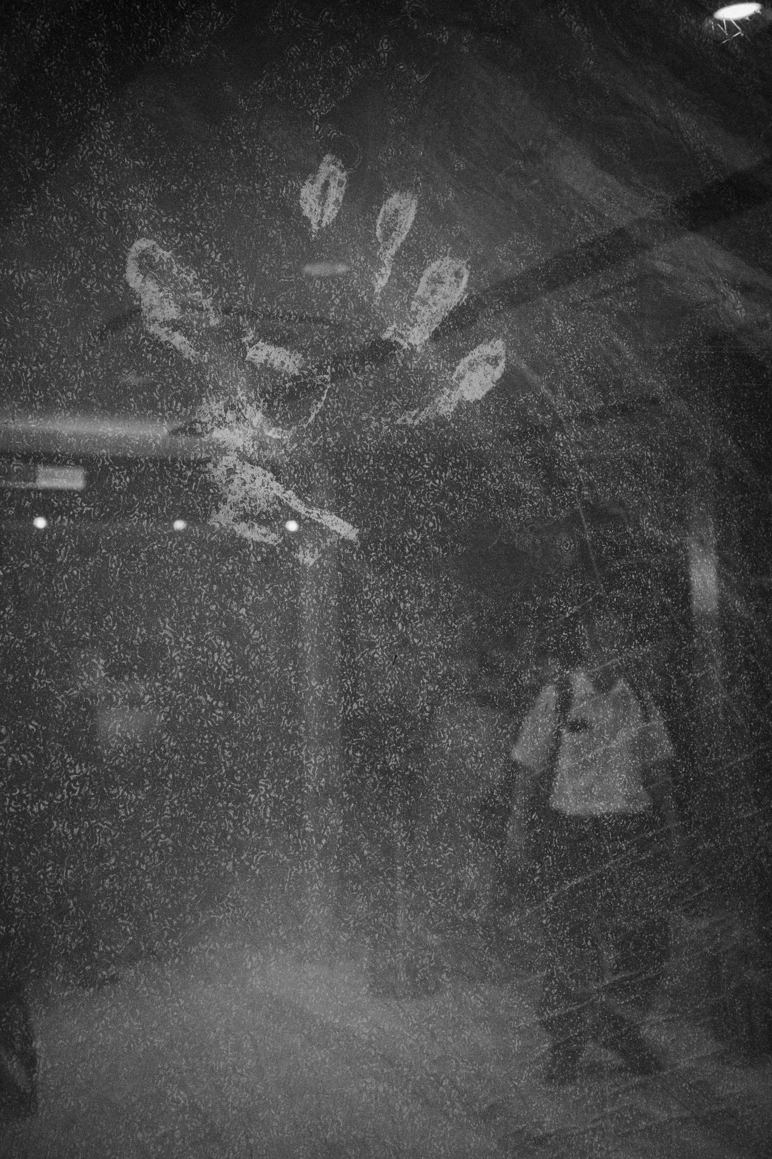 Image en noir et blanc présentant une œuvre d'art en forme de mains émergeant de la brume