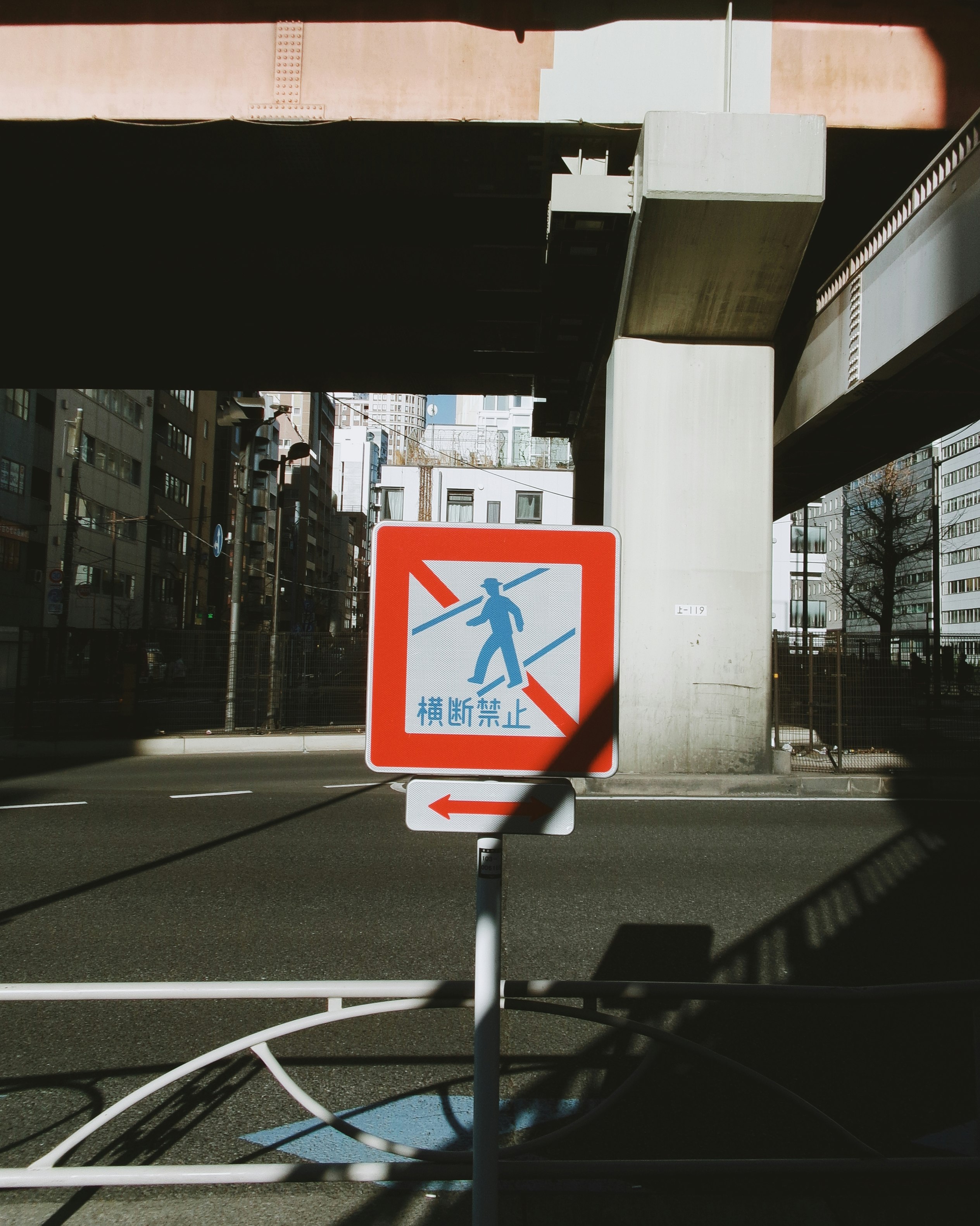 street scene with a pedestrian crossing stop sign at an intersection