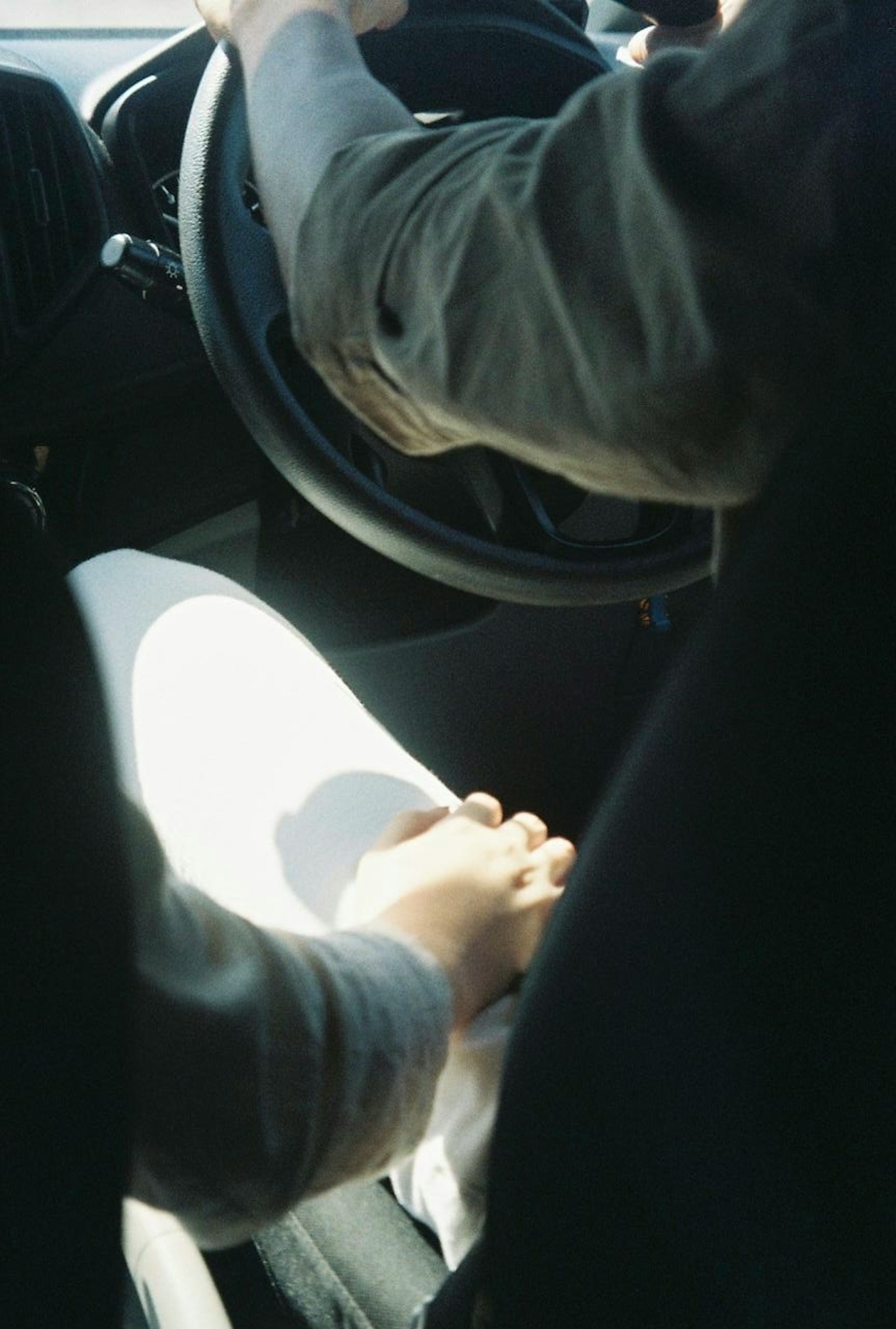 Paar, das sich beim Fahren in einem Auto die Hände hält