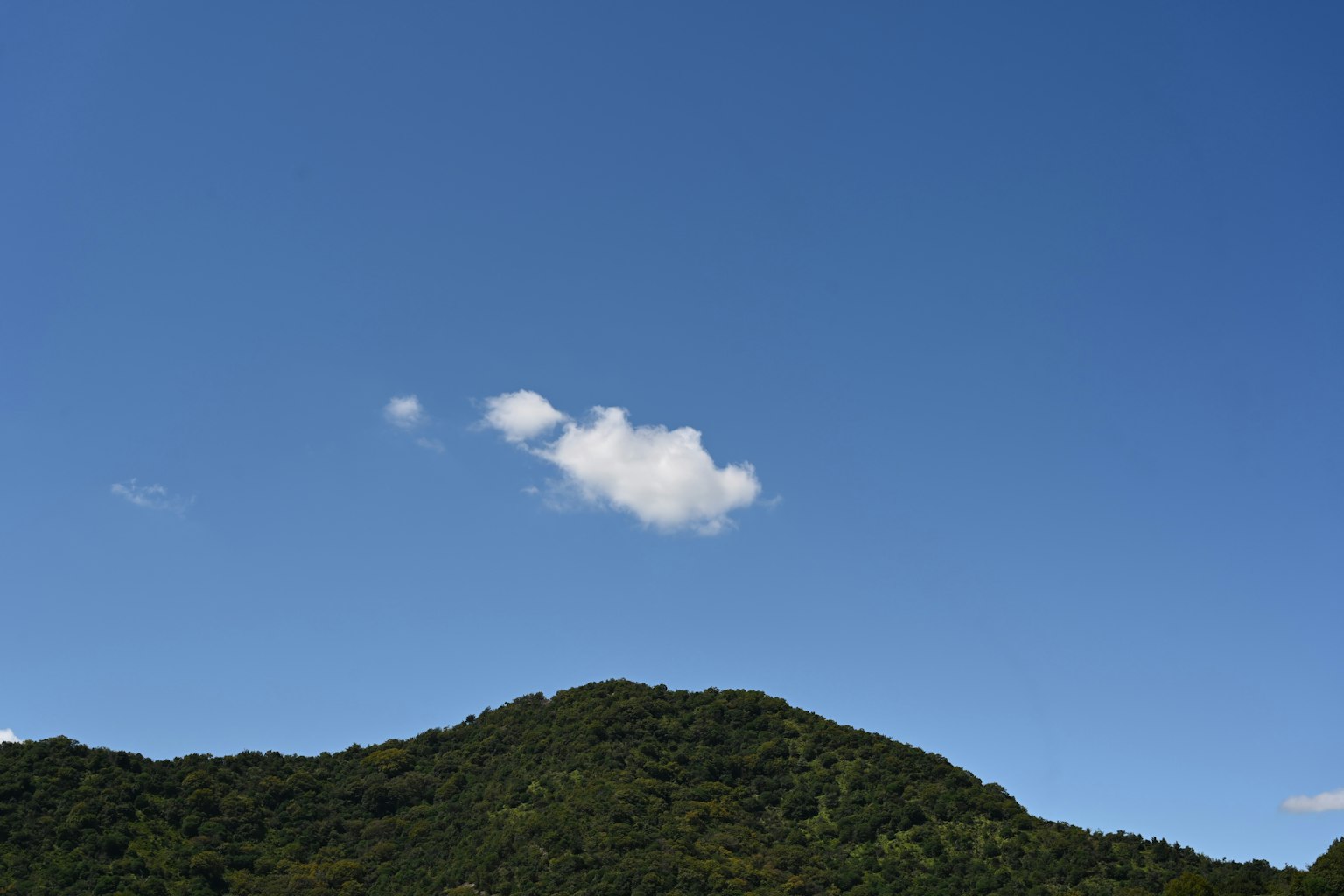Pemandangan dengan langit biru dan gunung hijau