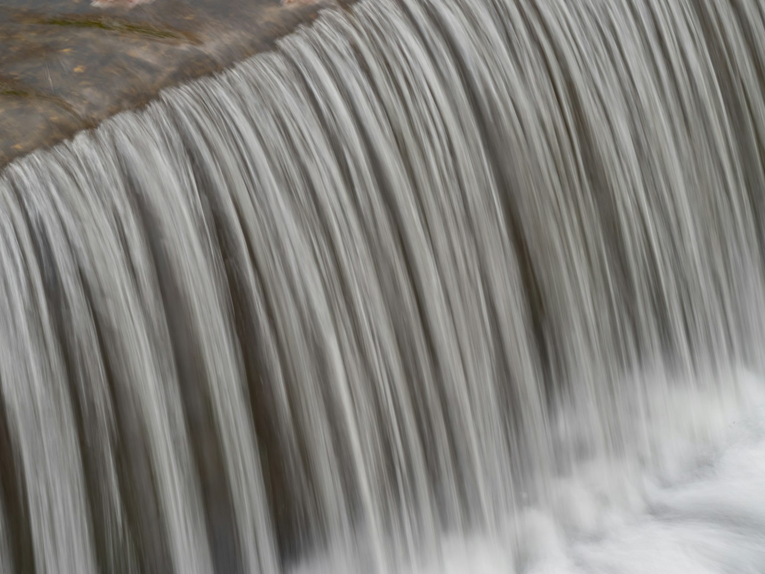 Primo piano di una cascata con acqua che scorre liscia e trame sottili