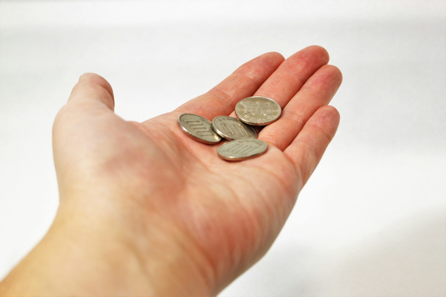 Une main tenant plusieurs pièces de monnaie
