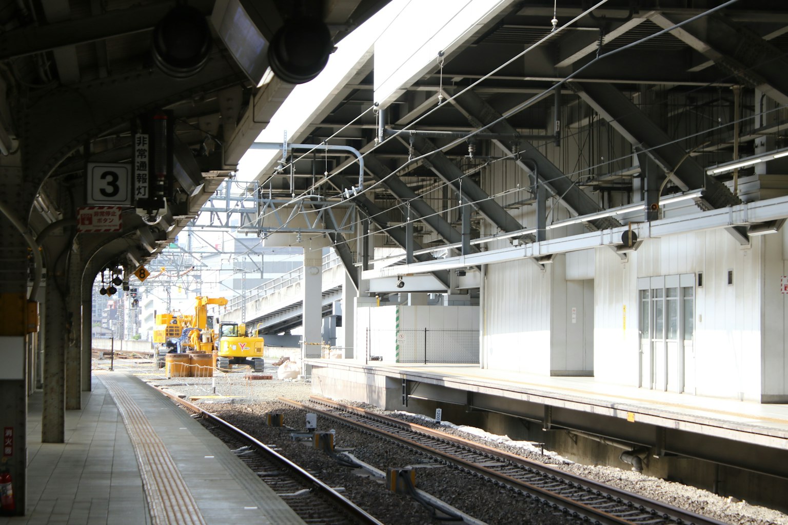 火車站台和軌道的景觀 看到一台黃色的施工機器