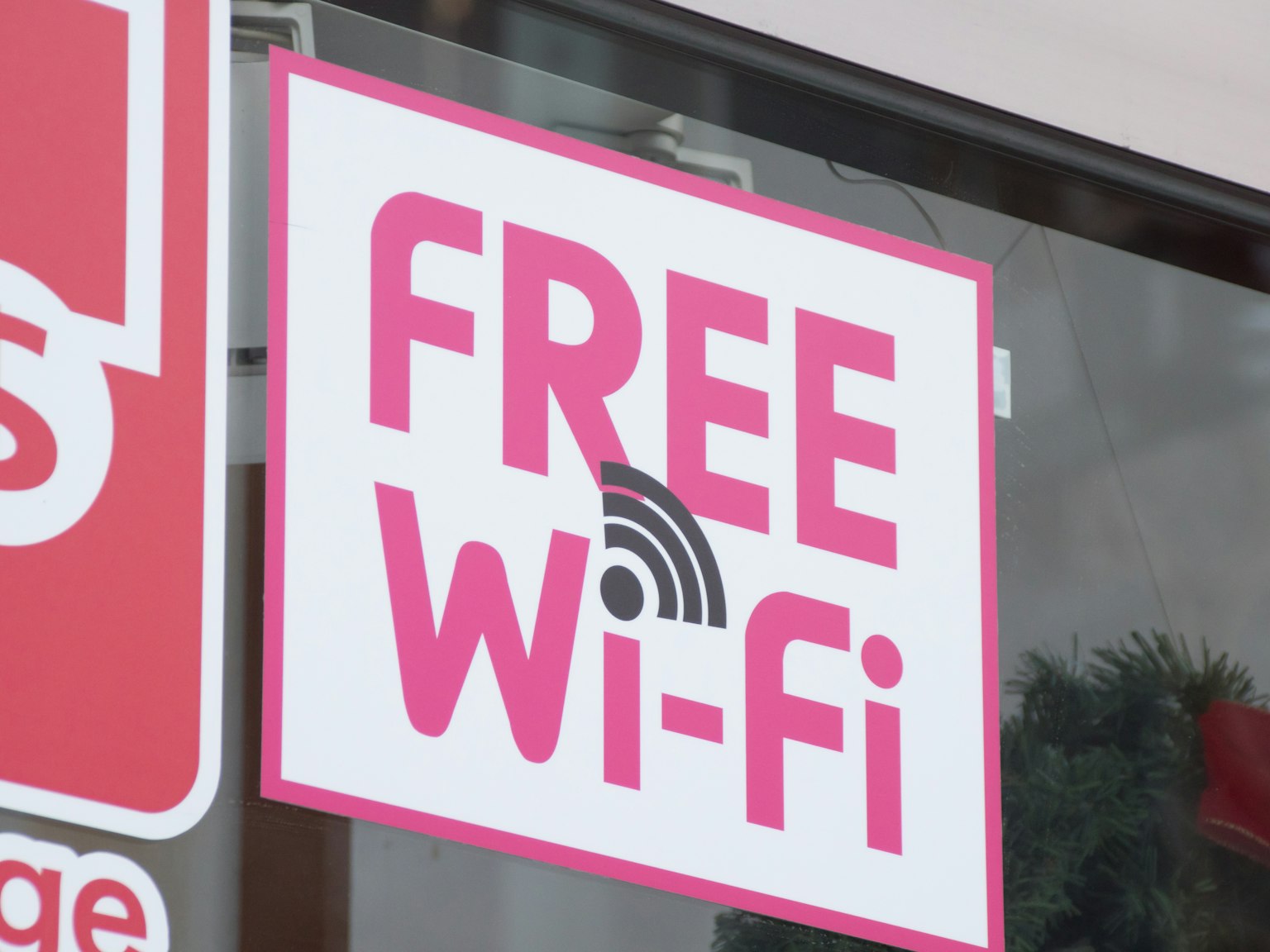 店舗の窓に掲示された無料Wi-Fiのサイン