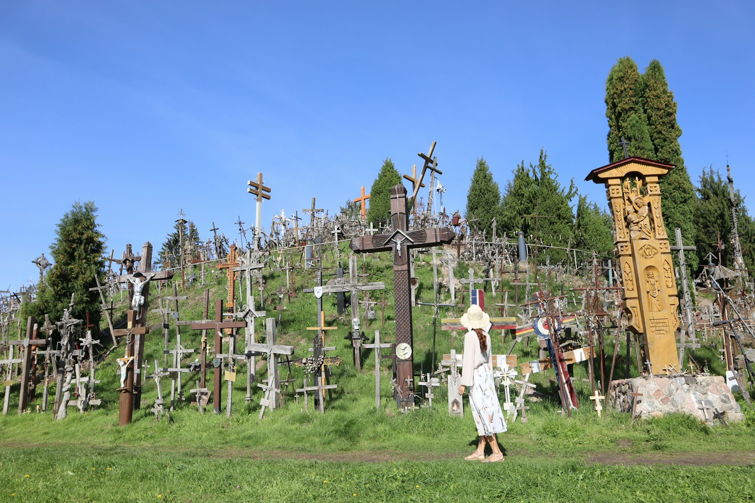 Collina coperta di numerose croci e una donna in abito bianco