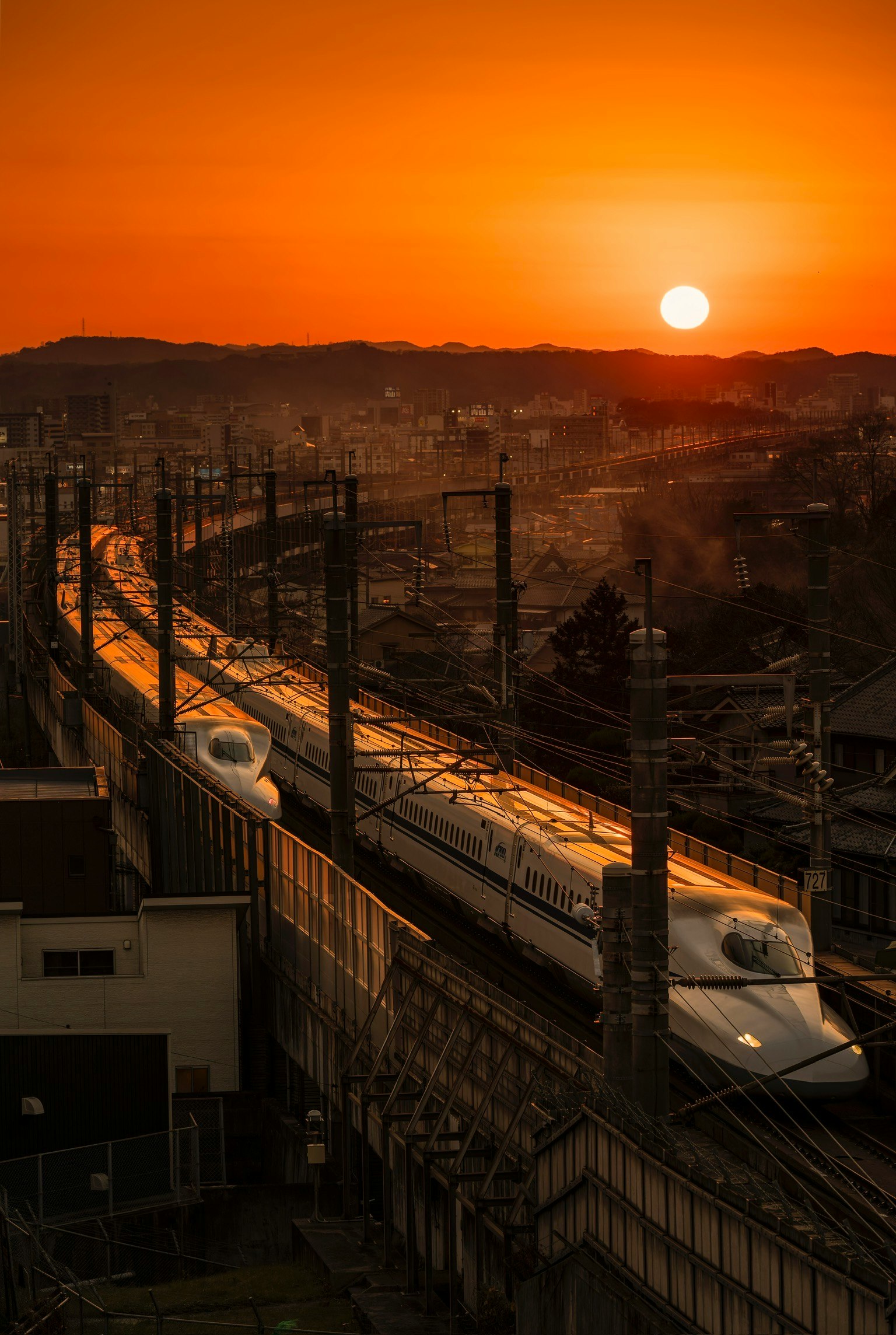 Tàu Shinkansen chạy dưới nền hoàng hôn
