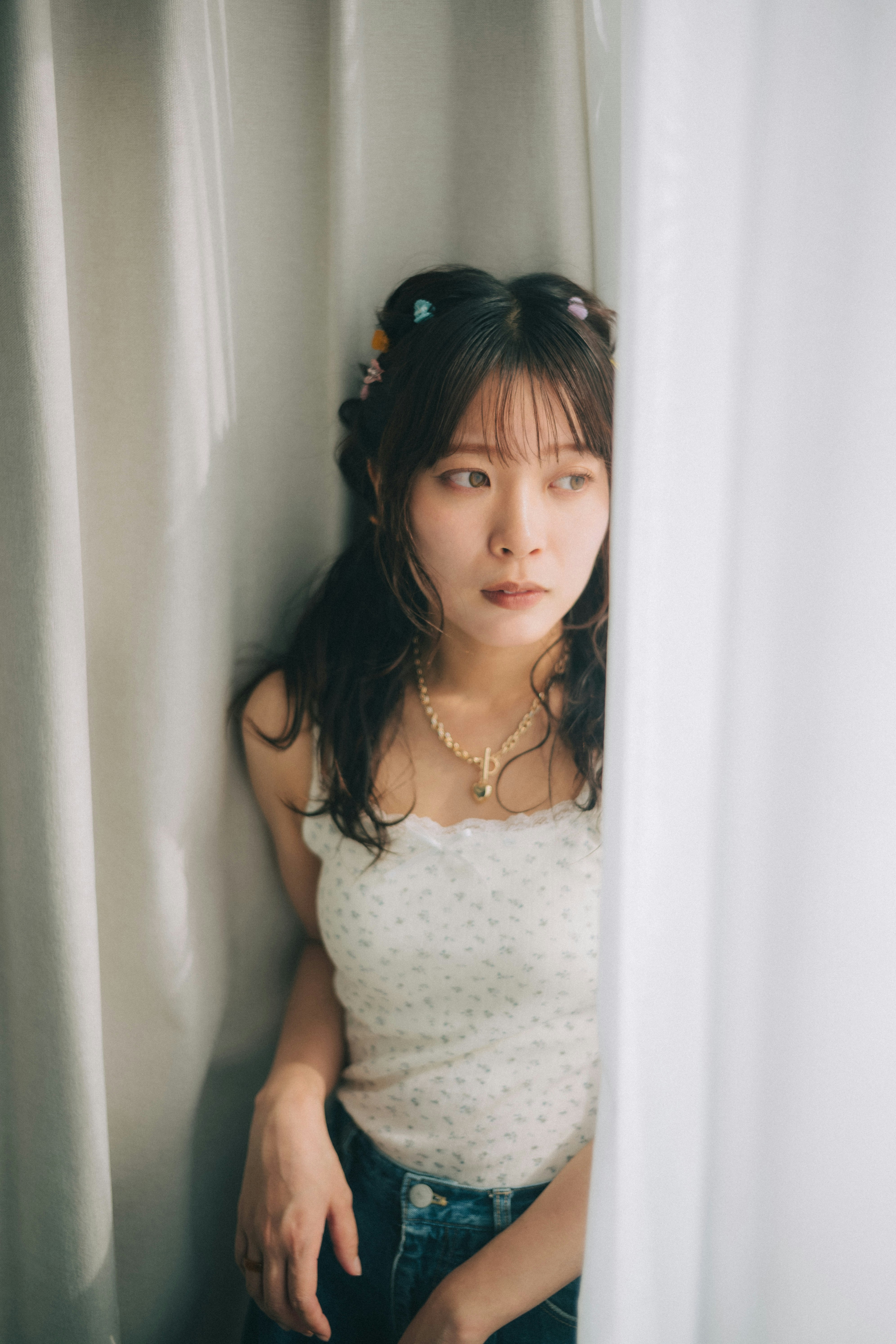 カーテンの前で微笑む女性のポートレート