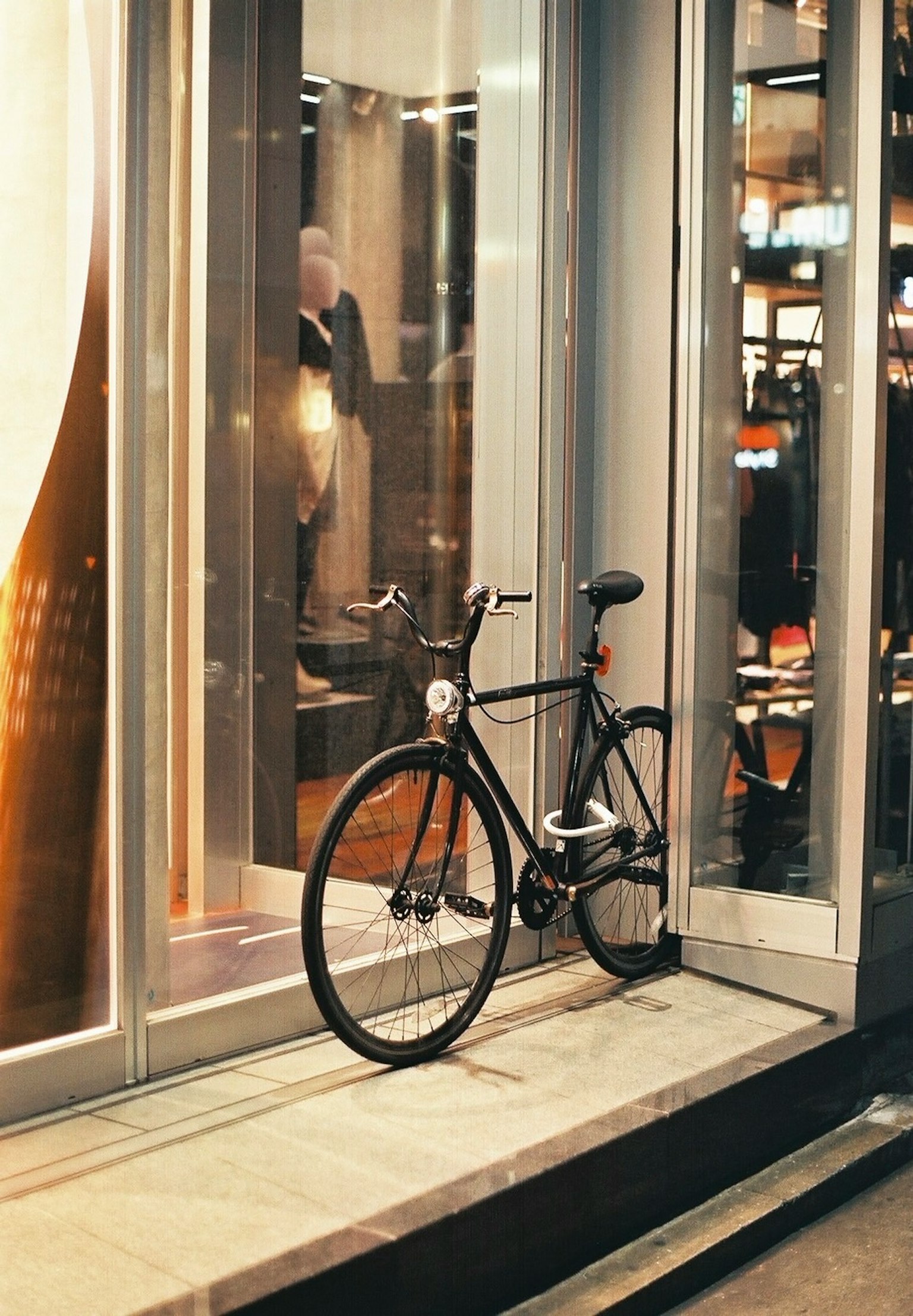 Una bicicletta nera parcheggiata accanto a una vetrina di vetro