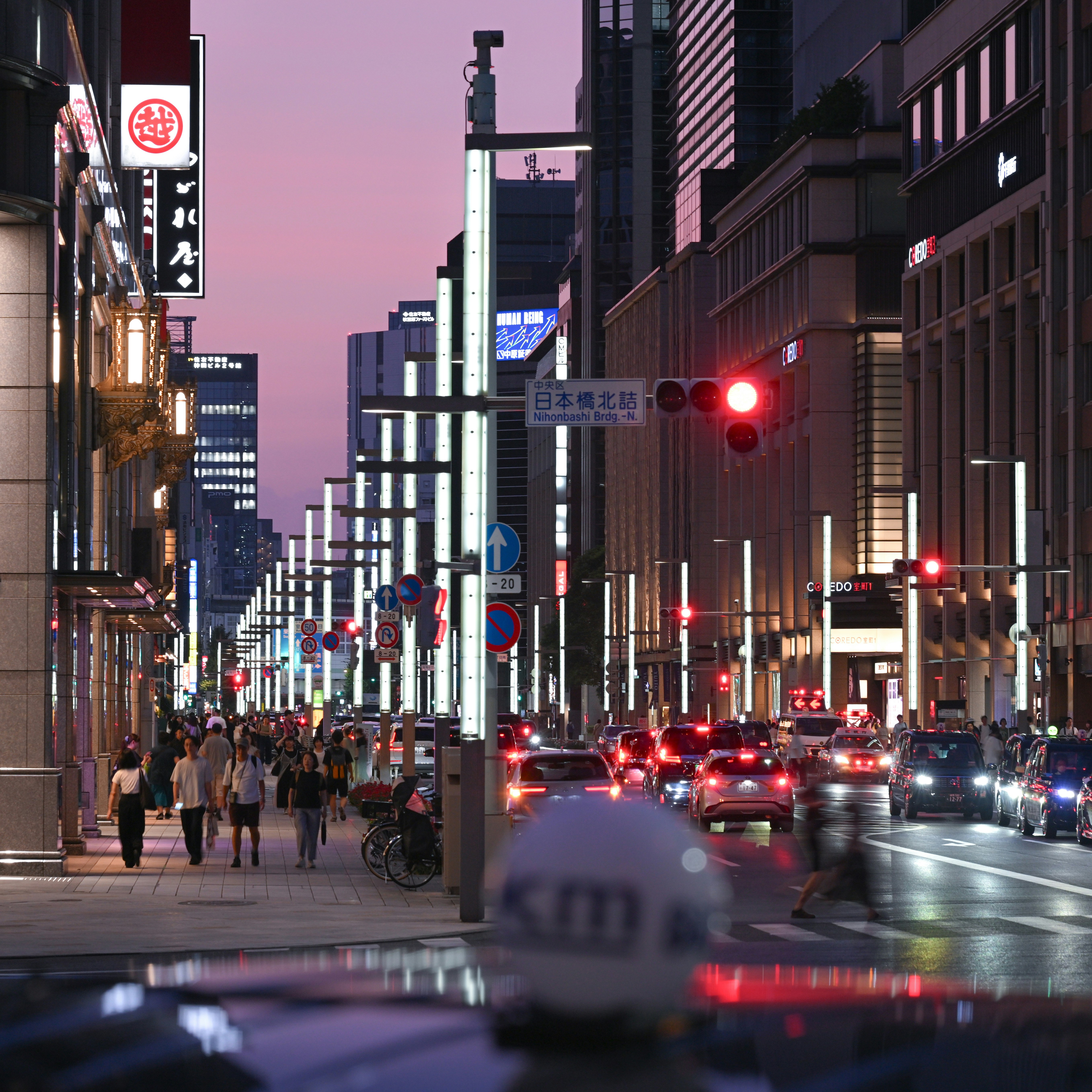 黃昏時分的城市街道，行人和車輛穿行
