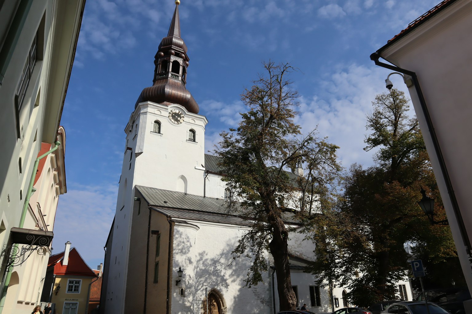 Tour d'église blanche contre un ciel bleu avec des nuages