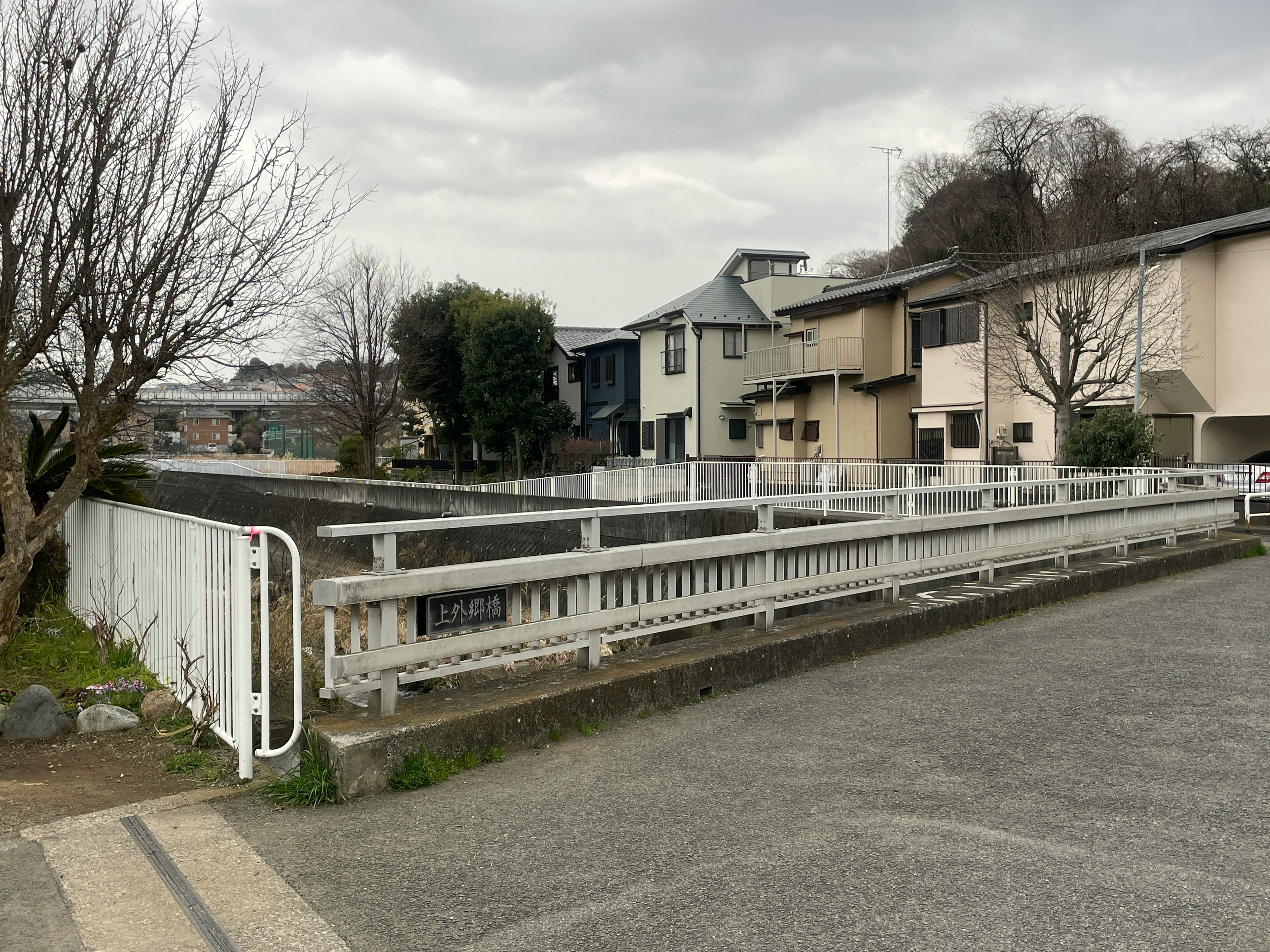 川沿いの遊歩道と低層住宅が並ぶ街角