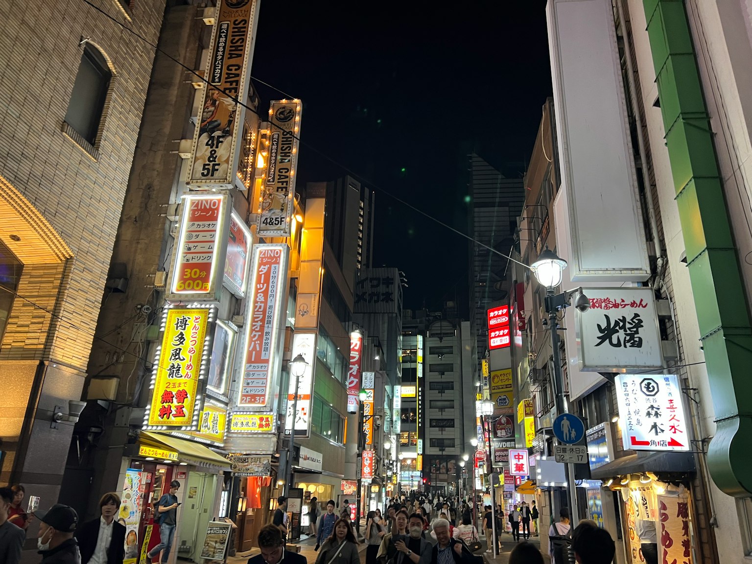 ถนนที่มีชีวิตชีวาในเวลากลางคืนพร้อมป้ายไฟนีออนสว่าง