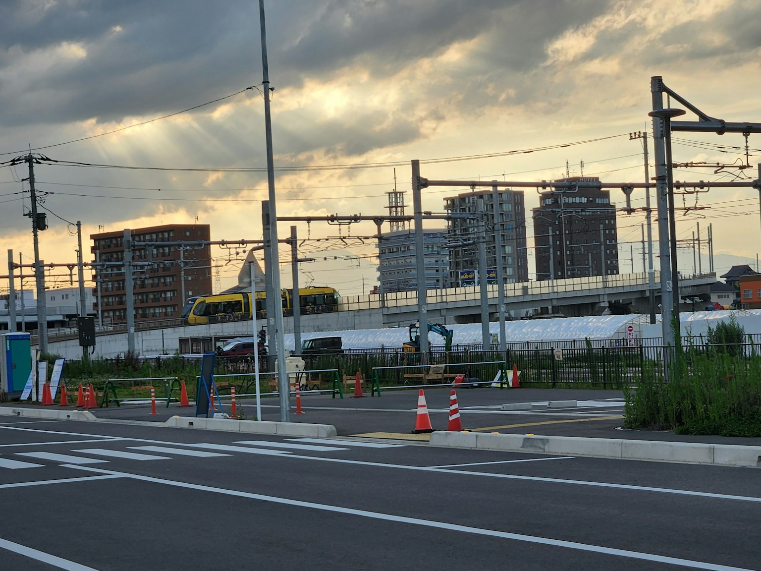 Hochhäuser entlang von Bahngleisen mit einem Sonnenuntergangshimmel