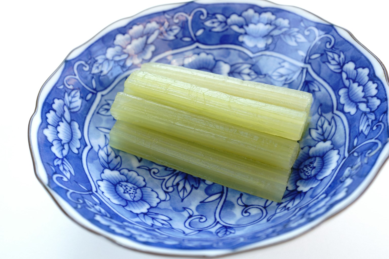 Lunghe coste di sedano disposte su un piatto a motivi floreali blu