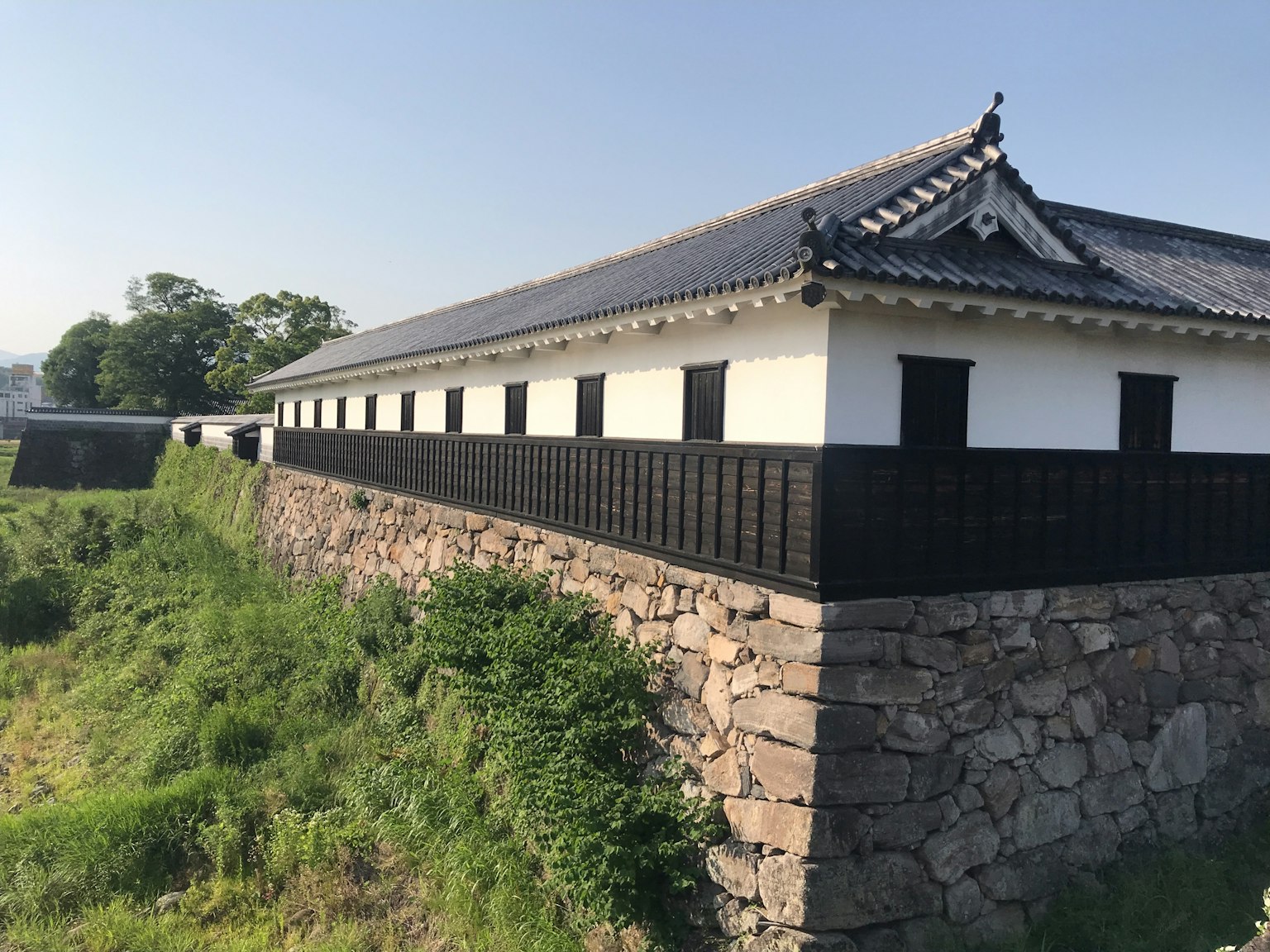 Vista lateral de un edificio japonés tradicional sobre un muro de piedra