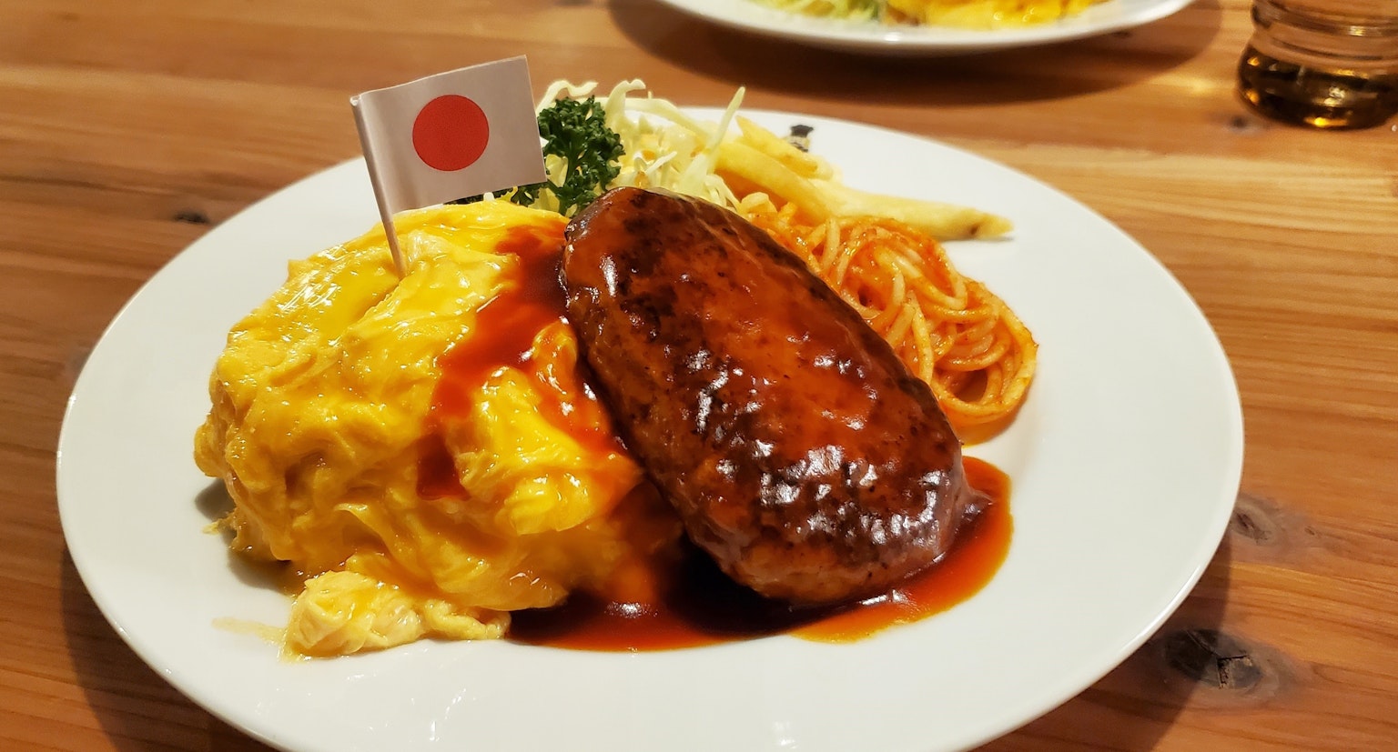 Plato de arroz omelette japonés con hamburguesa y bandera