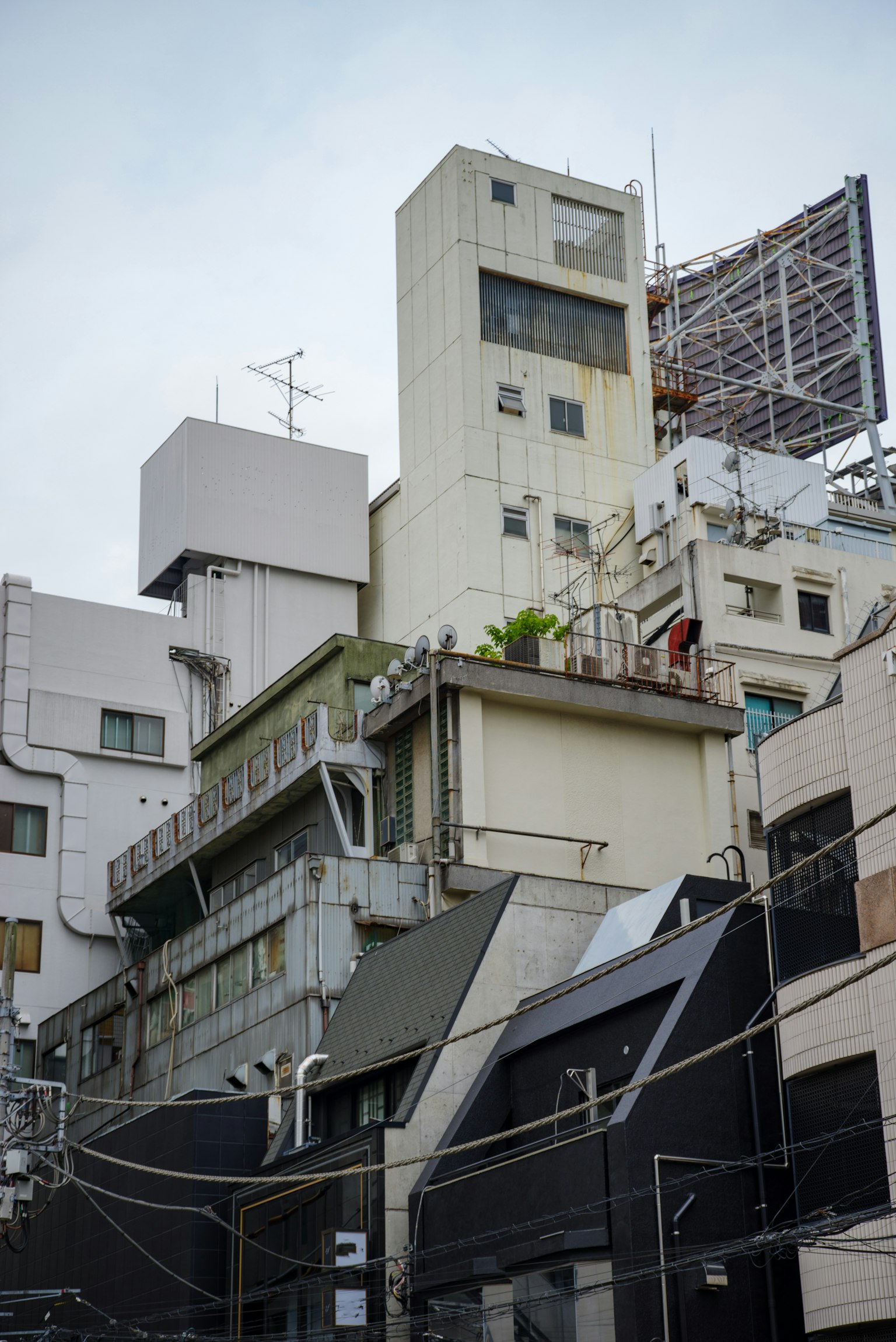 複雑な都市の建物群と異なる形状の構造物が重なり合っている